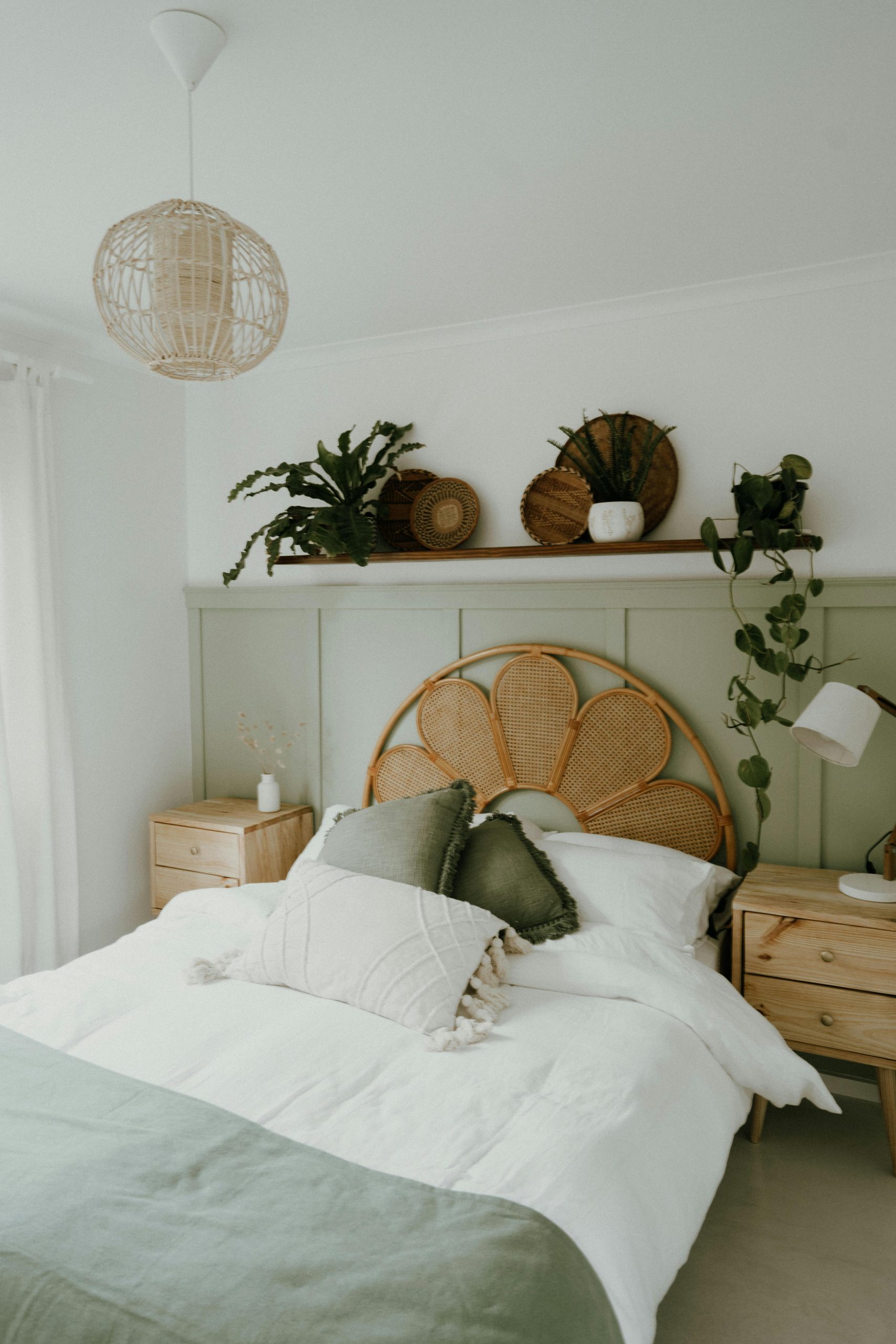 Comfortable bohemian bedroom featuring wicker details and green accents.