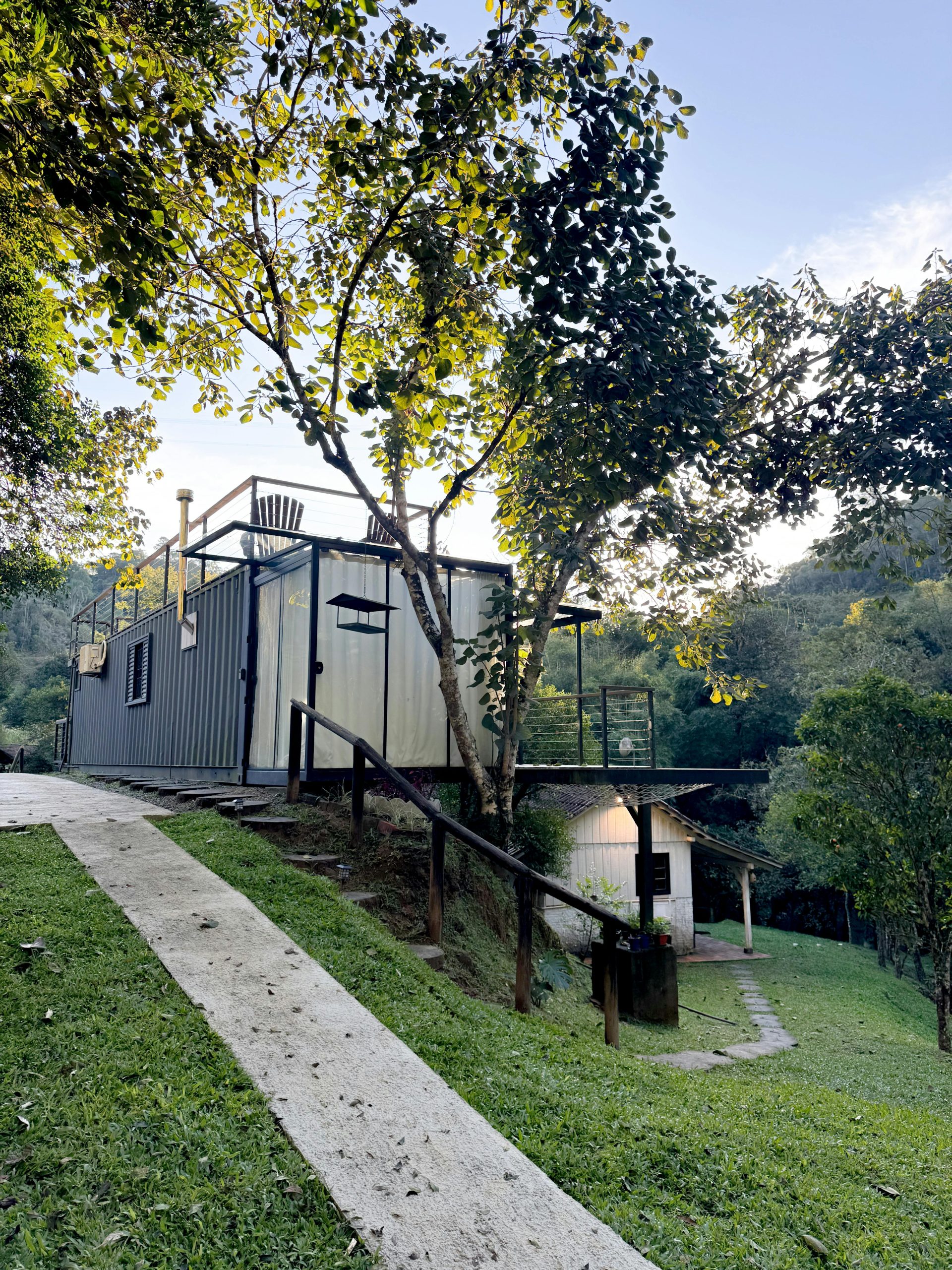 Container home among trees on a hillside, showcasing sustainable living