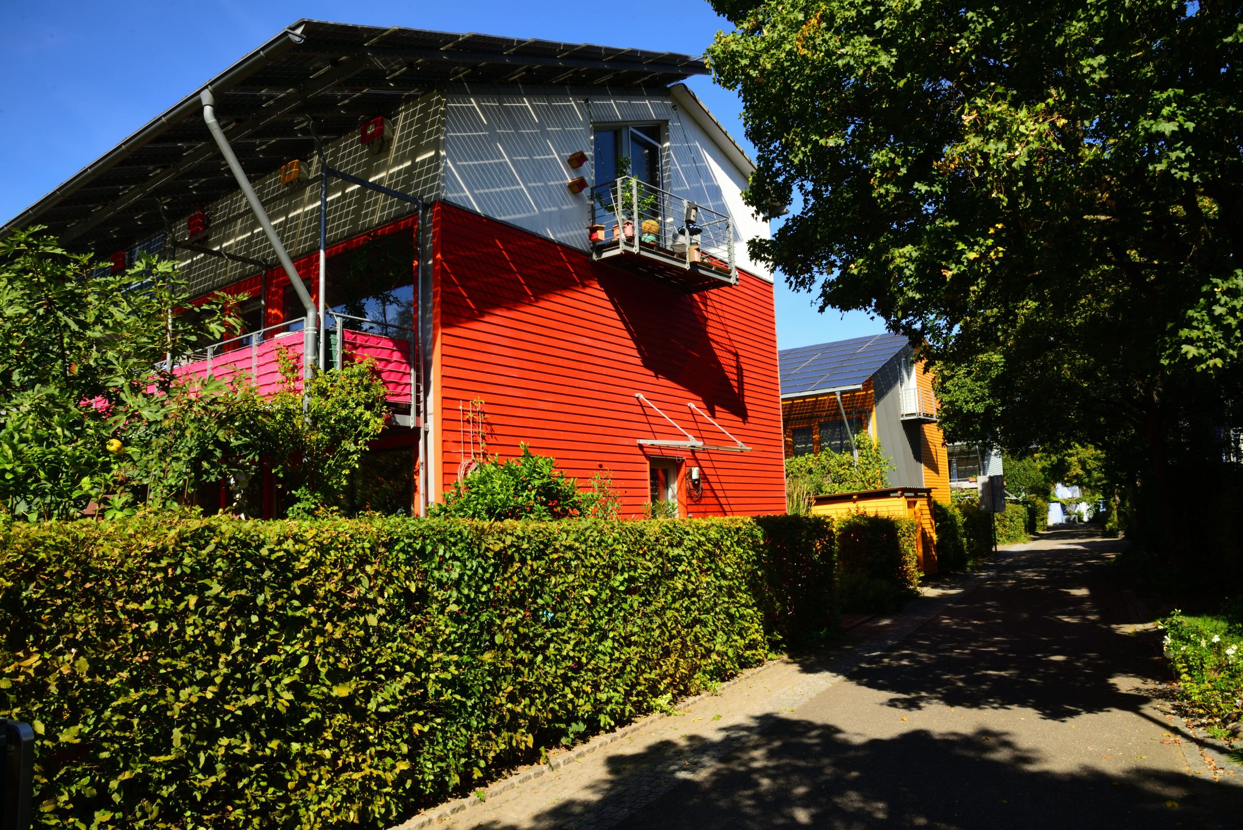 Contemporary solar-powered house in Freiburg surrounded by lush gardens, showcasing eco-friendly architecture.