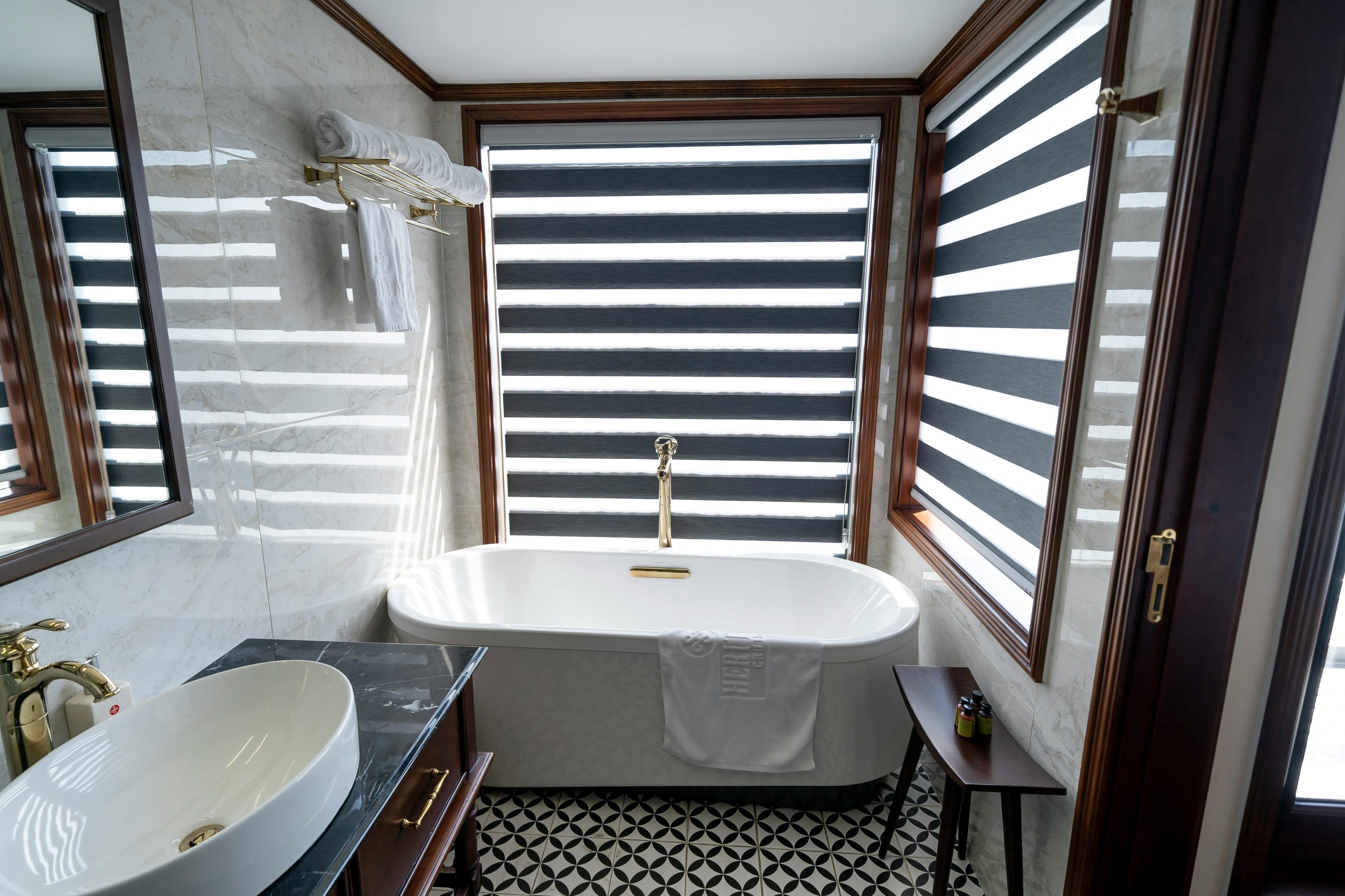 Elegant bathroom interior featuring a freestanding bathtub, marble walls, and modern fixtures.