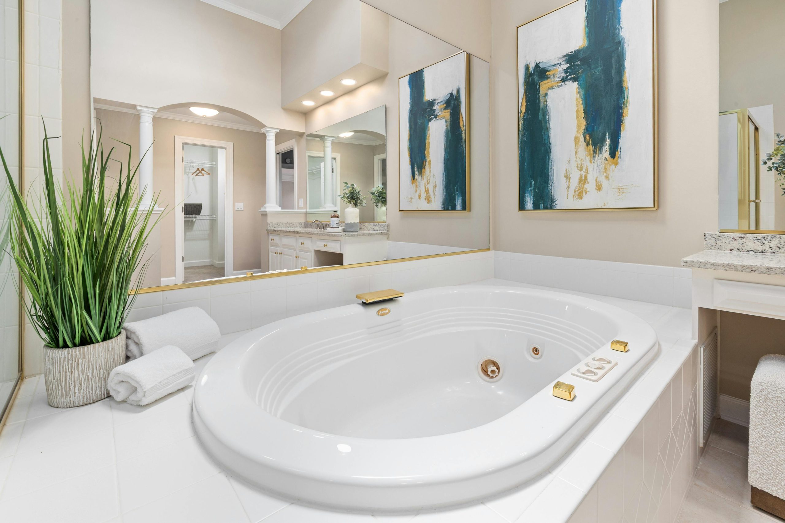 Elegant bathroom interior featuring a large whirlpool bathtub, modern art, and stylish decor.