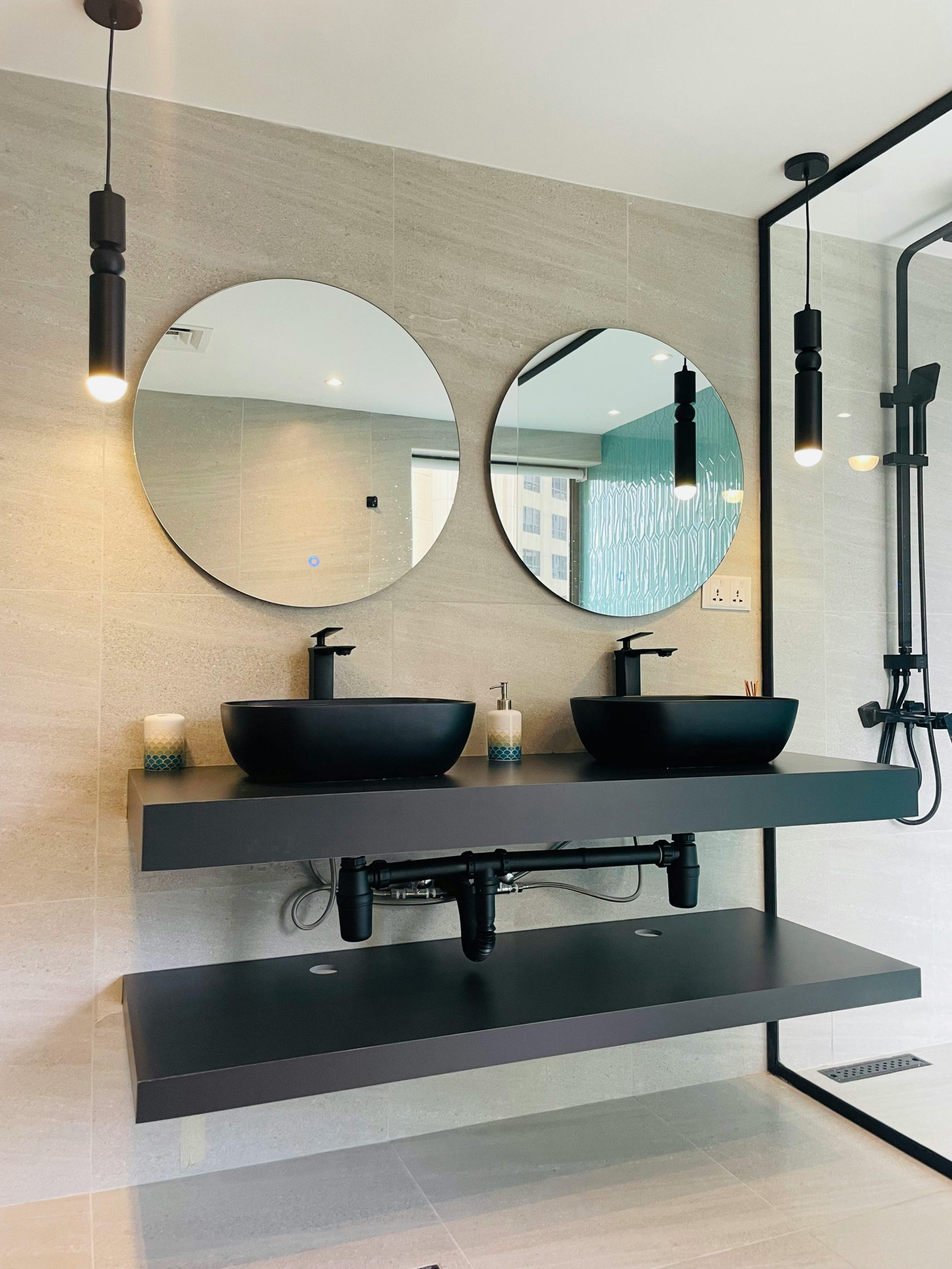 Elegant bathroom interior featuring double sinks and round mirrors.