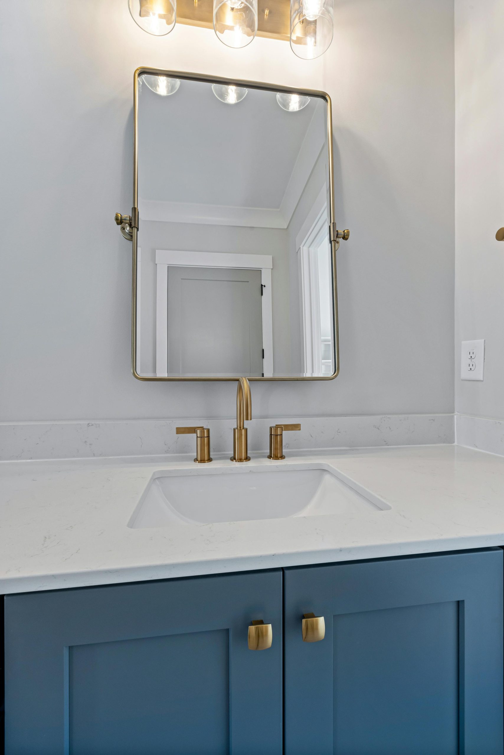 Elegant bathroom with minimalist vanity, chic mirror, and modern faucet design.