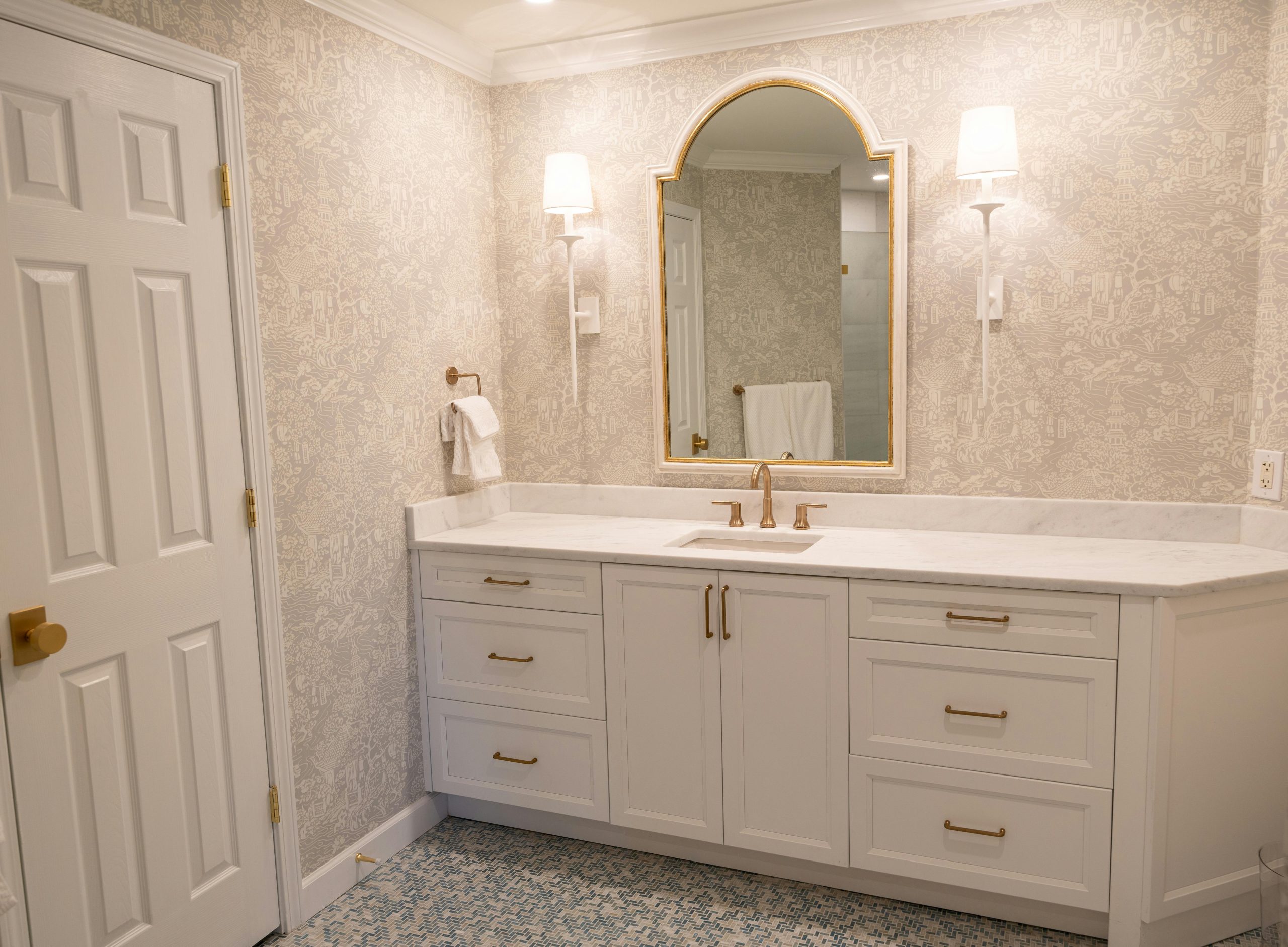 Elegant bathroom with white vanity, mirror, and soft lighting creating a luxurious ambiance.