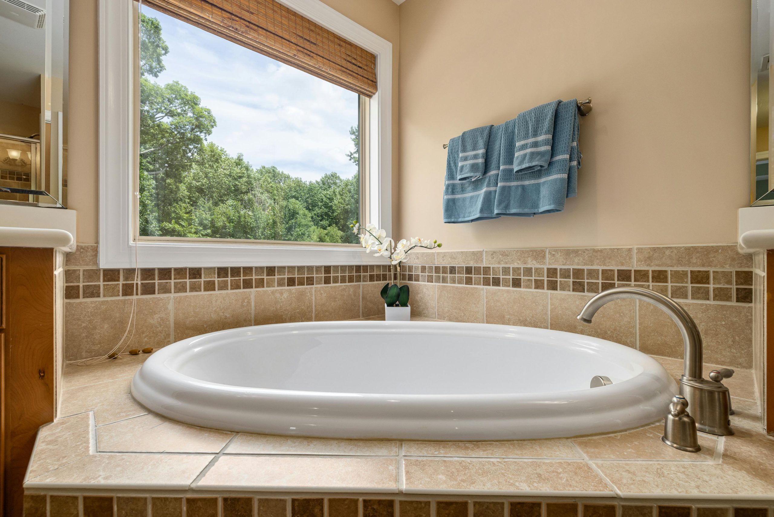 Elegant bathtub in a luxury bathroom with scenic window view, showcasing minimalist interior design.