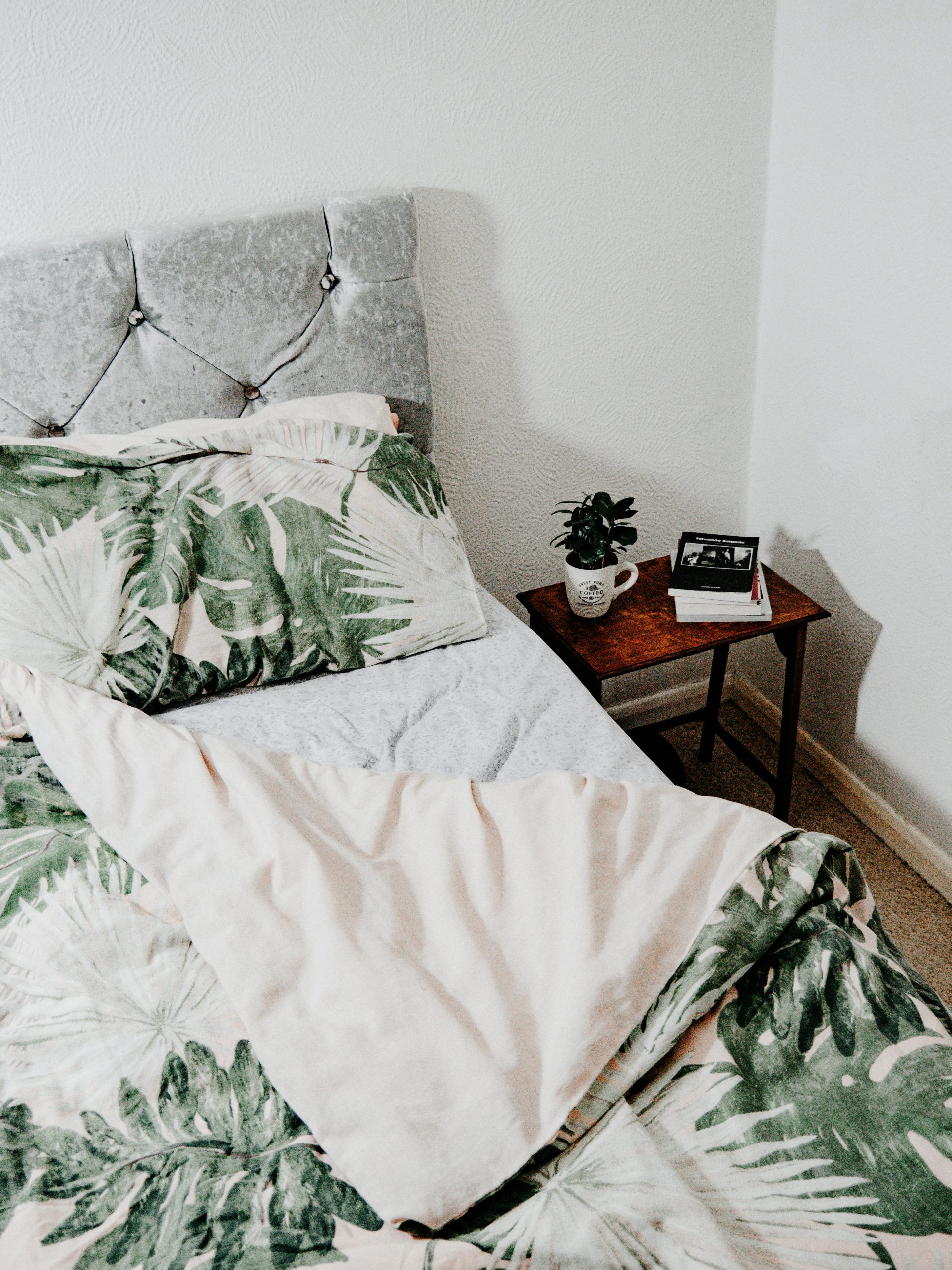 Inviting bedroom featuring tropical leaf bedding and cozy interior design.