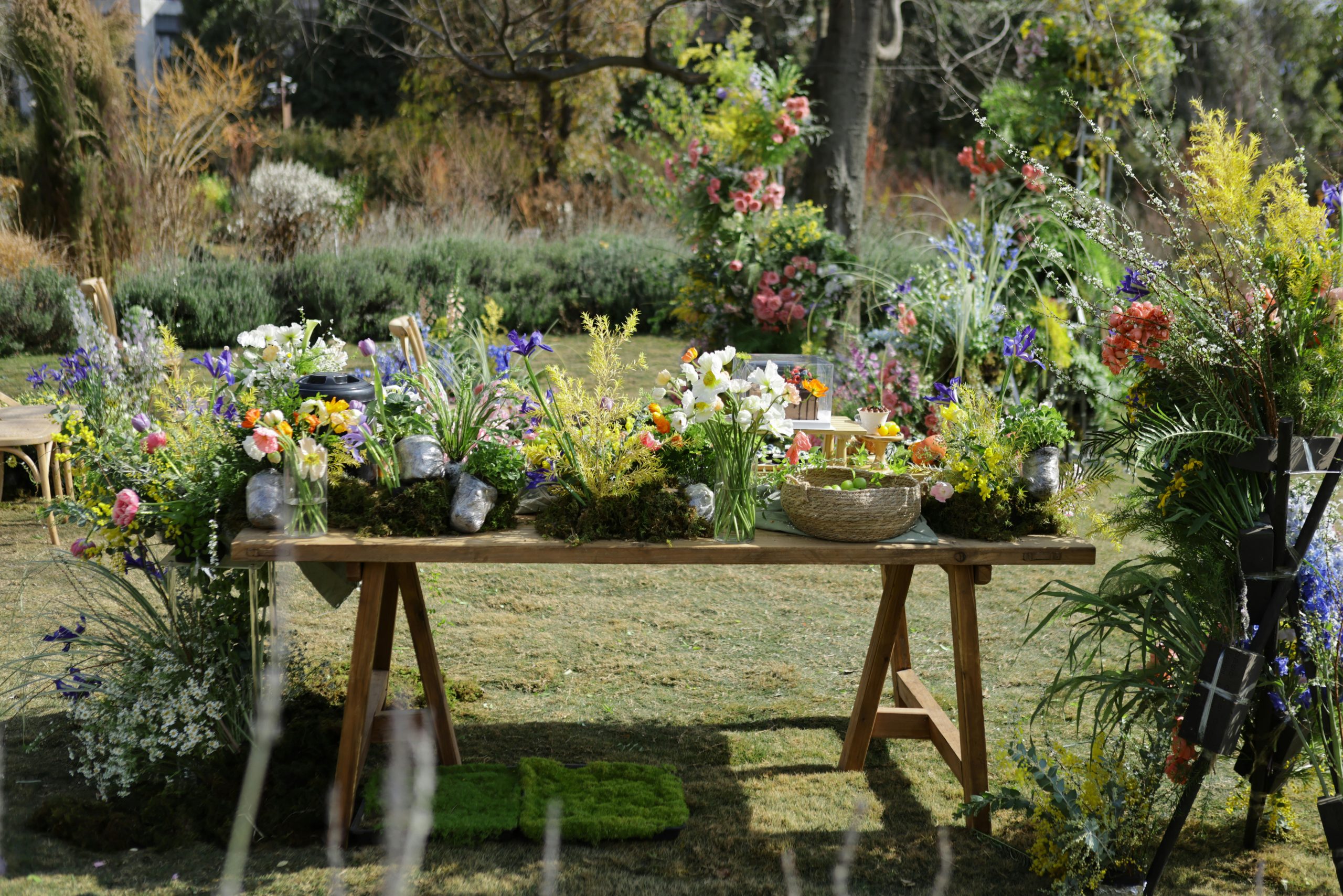 Lush floral display on table in vibrant outdoor garden setting.