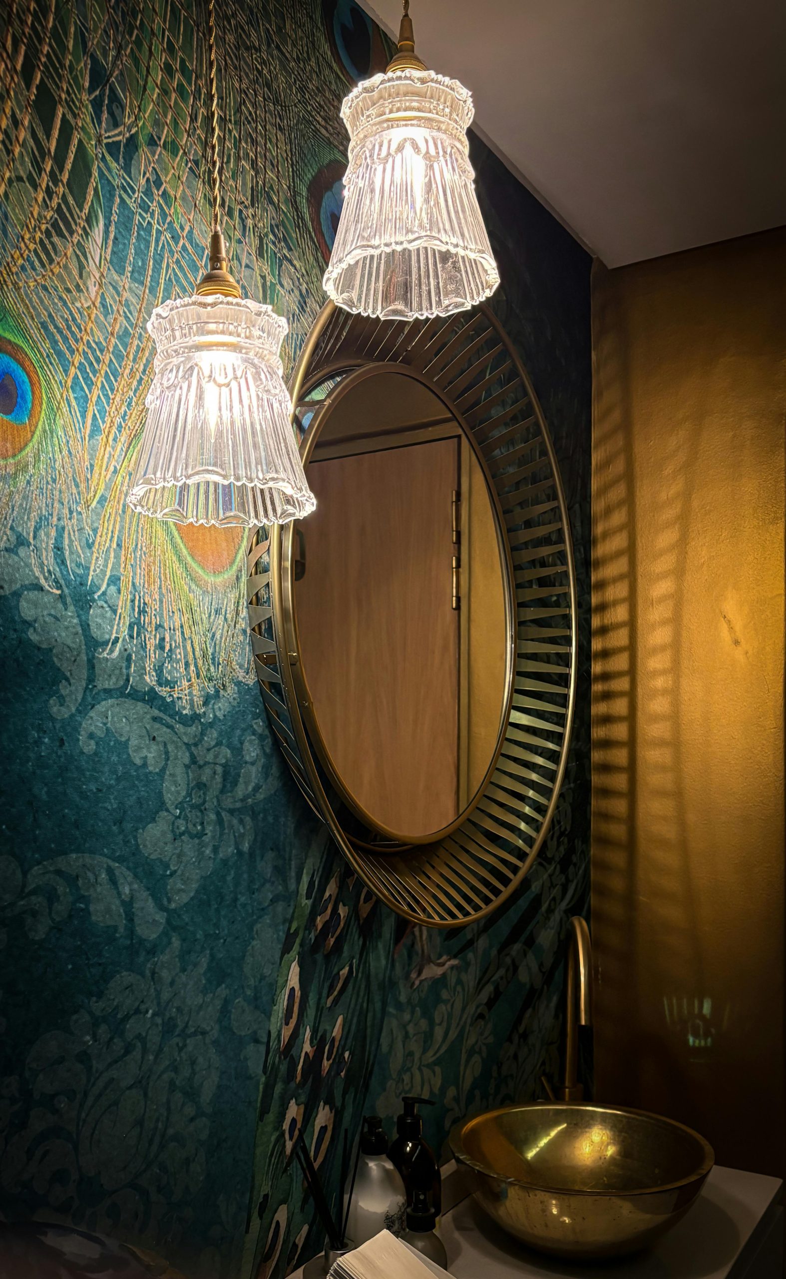 Luxurious bathroom featuring ornate mirror, gold faucet, and elegant lighting.