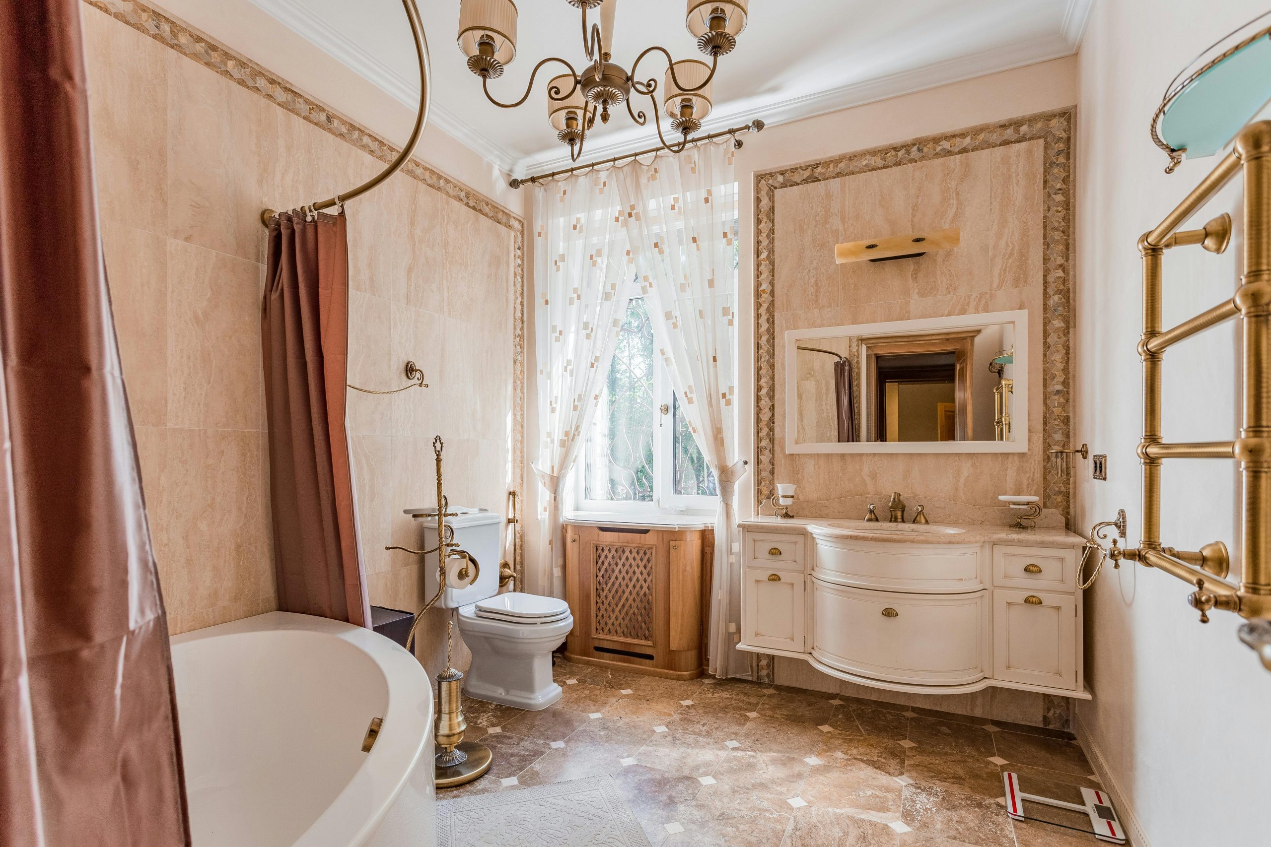 Luxurious vintage bathroom featuring a chandelier, bathtub, and elegant decor. Perfect for interior design inspiration.