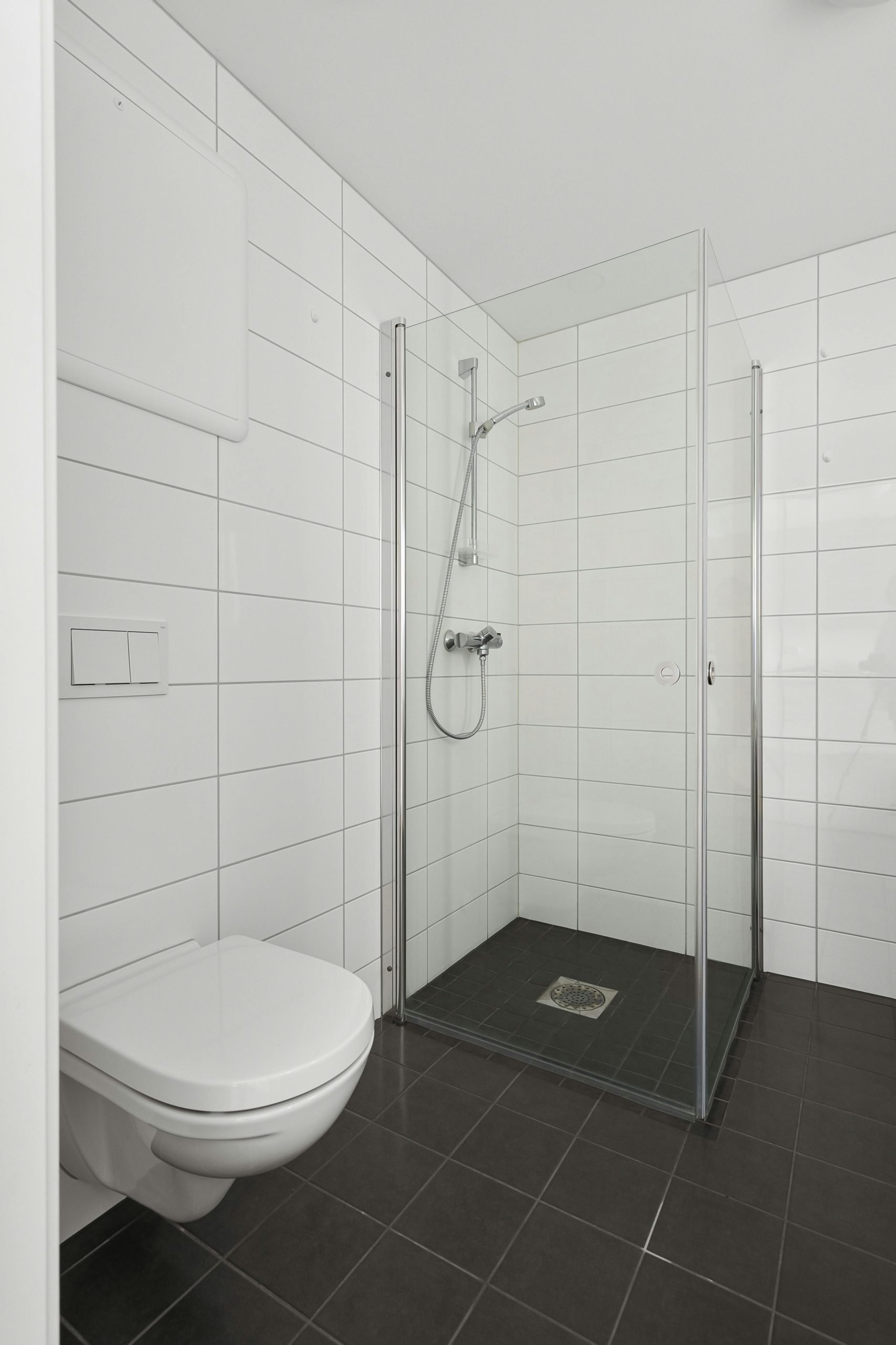 Minimalist bathroom design featuring a glass-enclosed shower and modern fixtures.