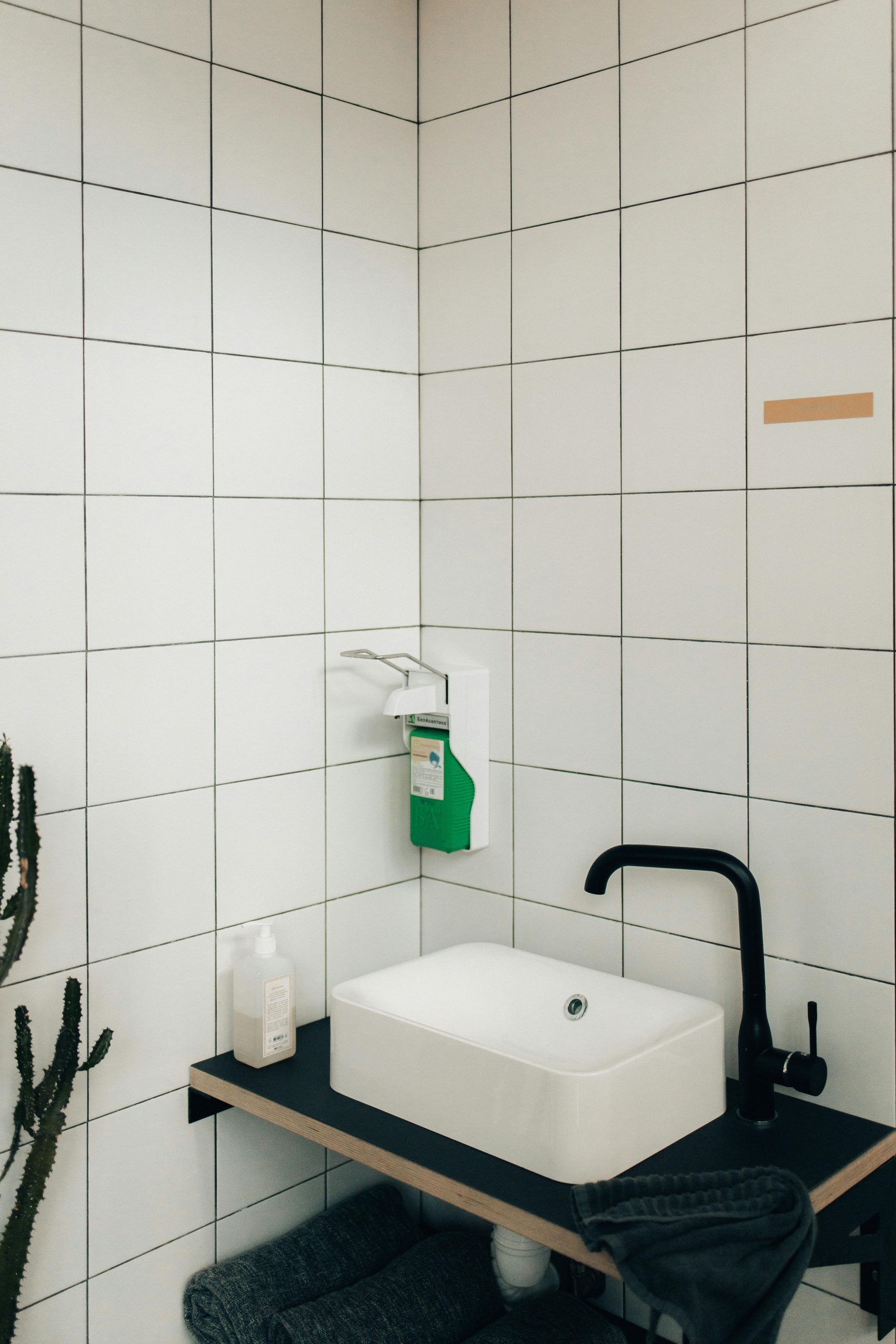 Modern bathroom showcasing sleek faucet and tiled walls in a minimalist design.
