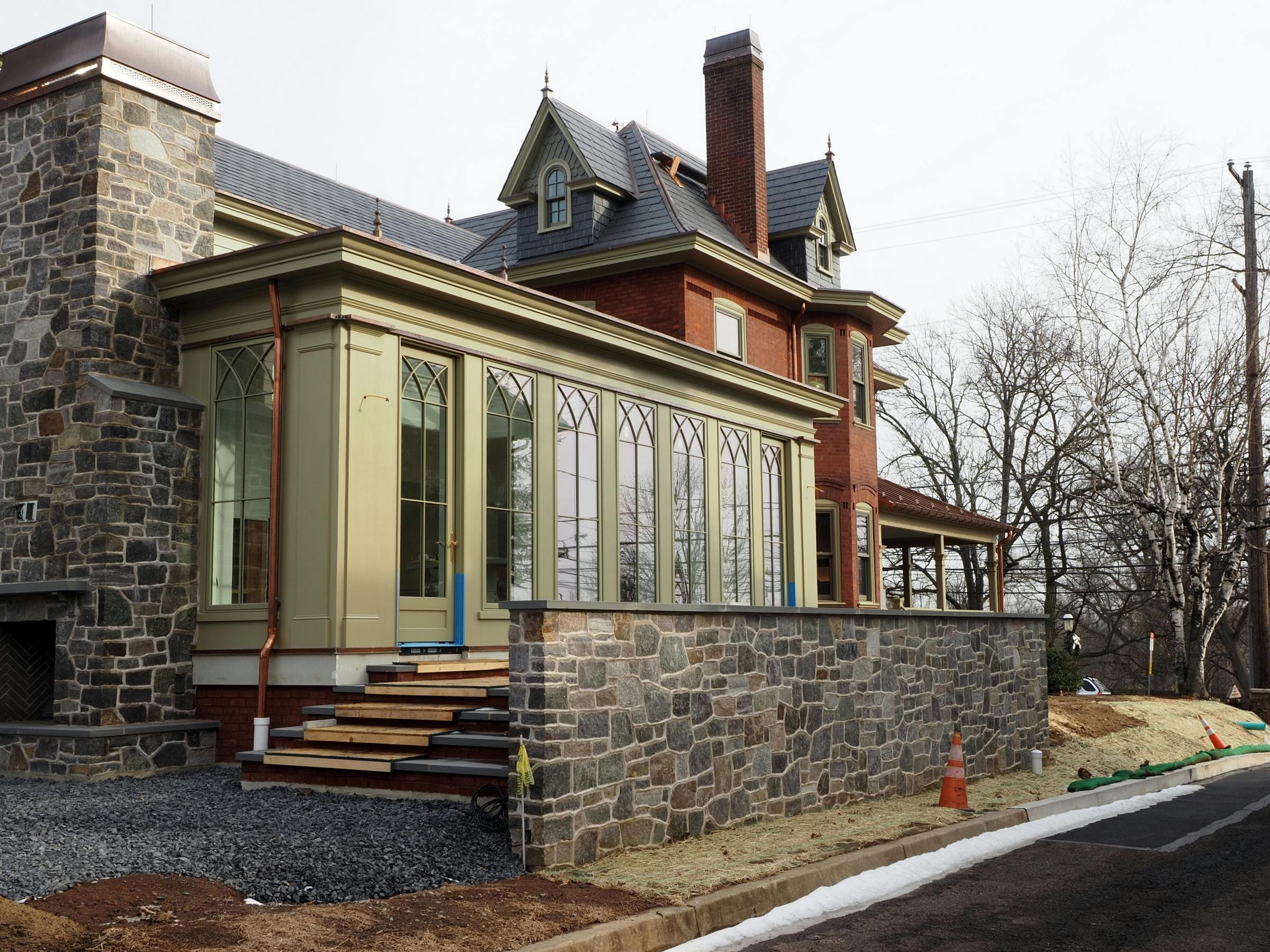 Renovated historic house in Doylestown, PA featuring a modern sunroom and stone architecture.