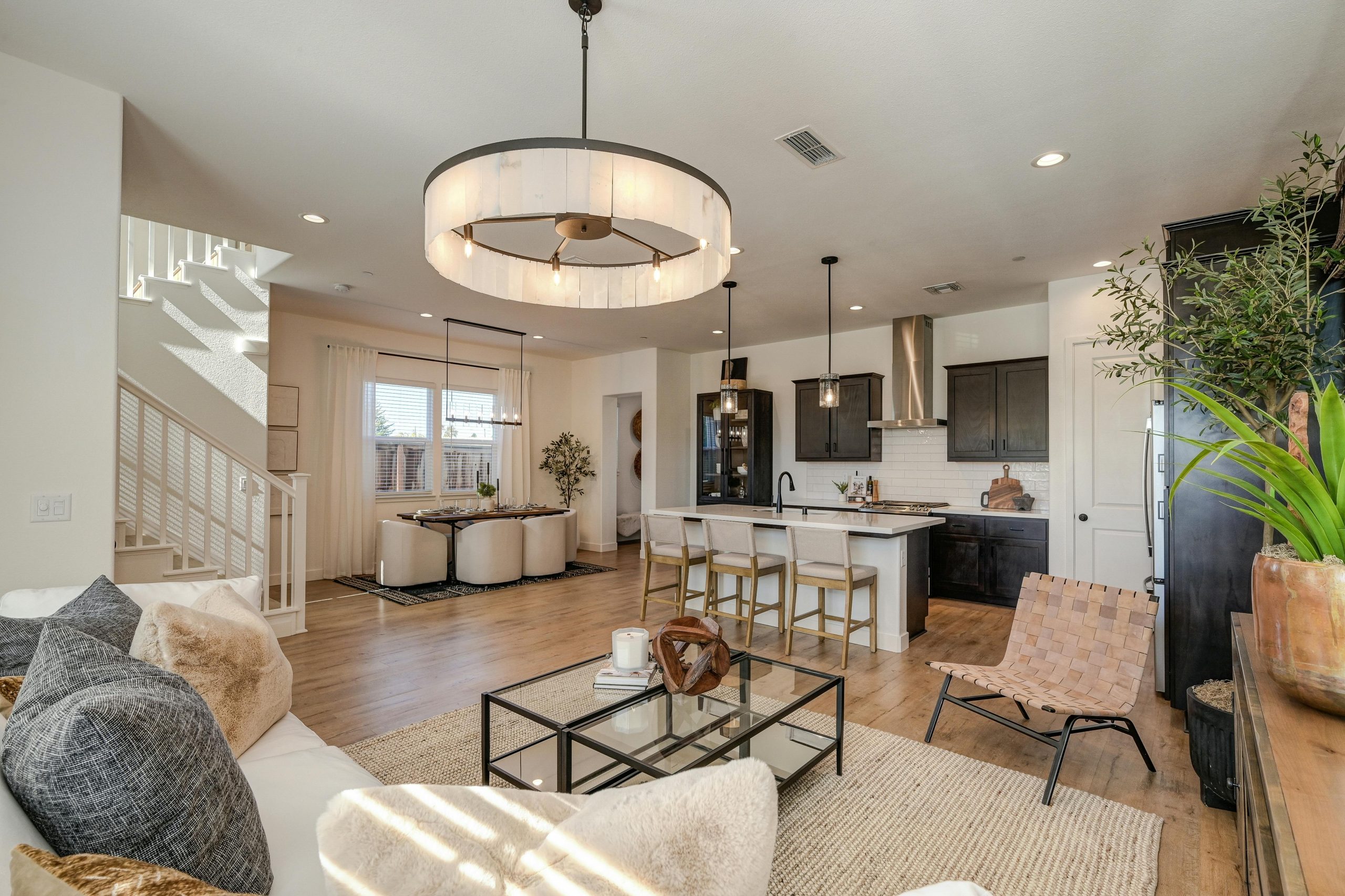 Sleek and stylish modern kitchen and living room with elegant decor and natural lighting.