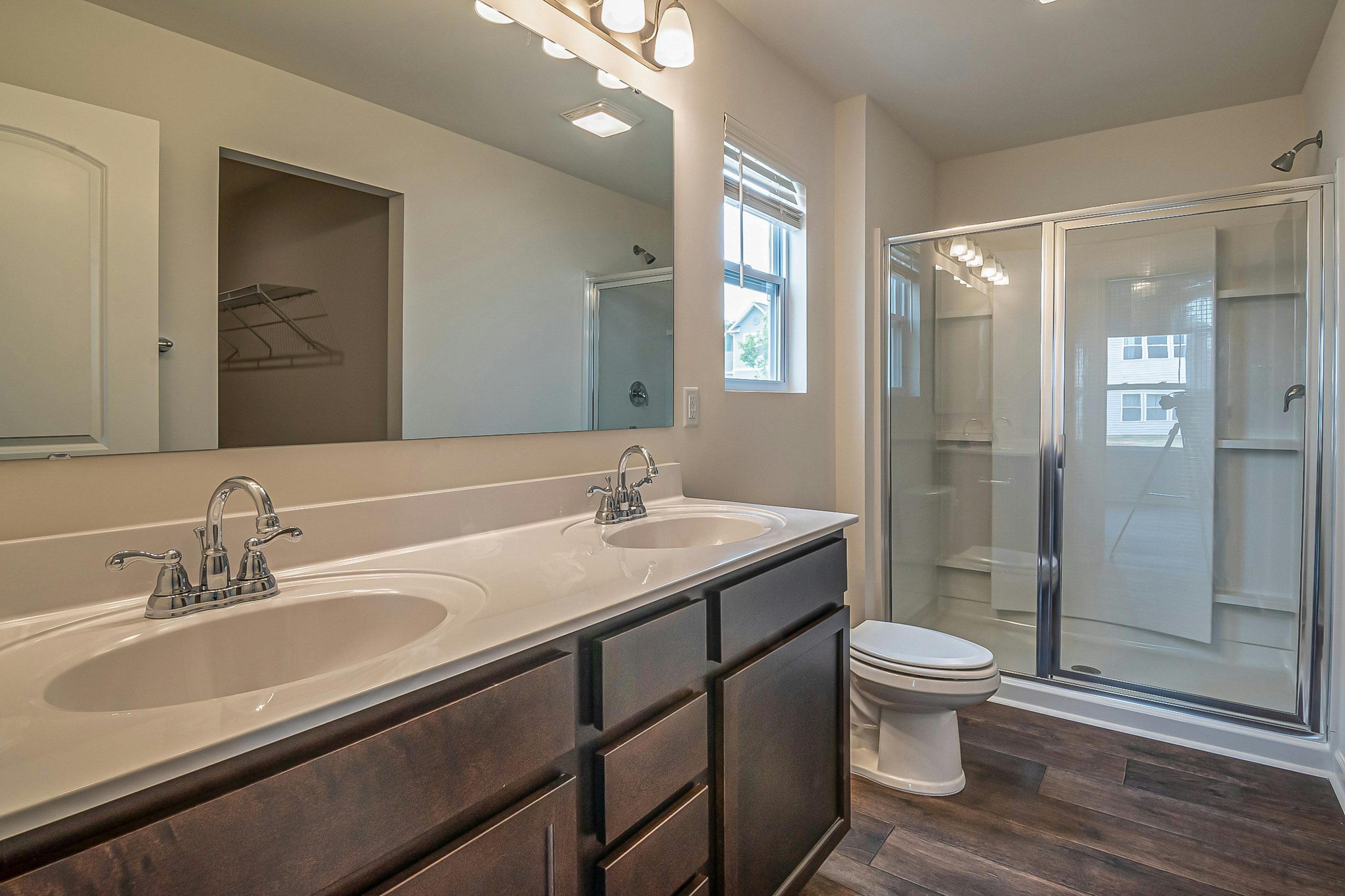 Spacious bathroom with dual sinks, glass shower, and contemporary design.