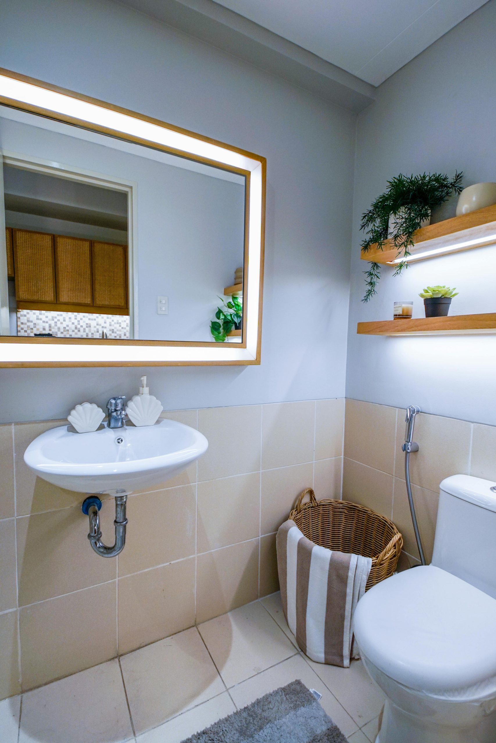 Stylish and clean minimalist bathroom with mirror and decor plants.