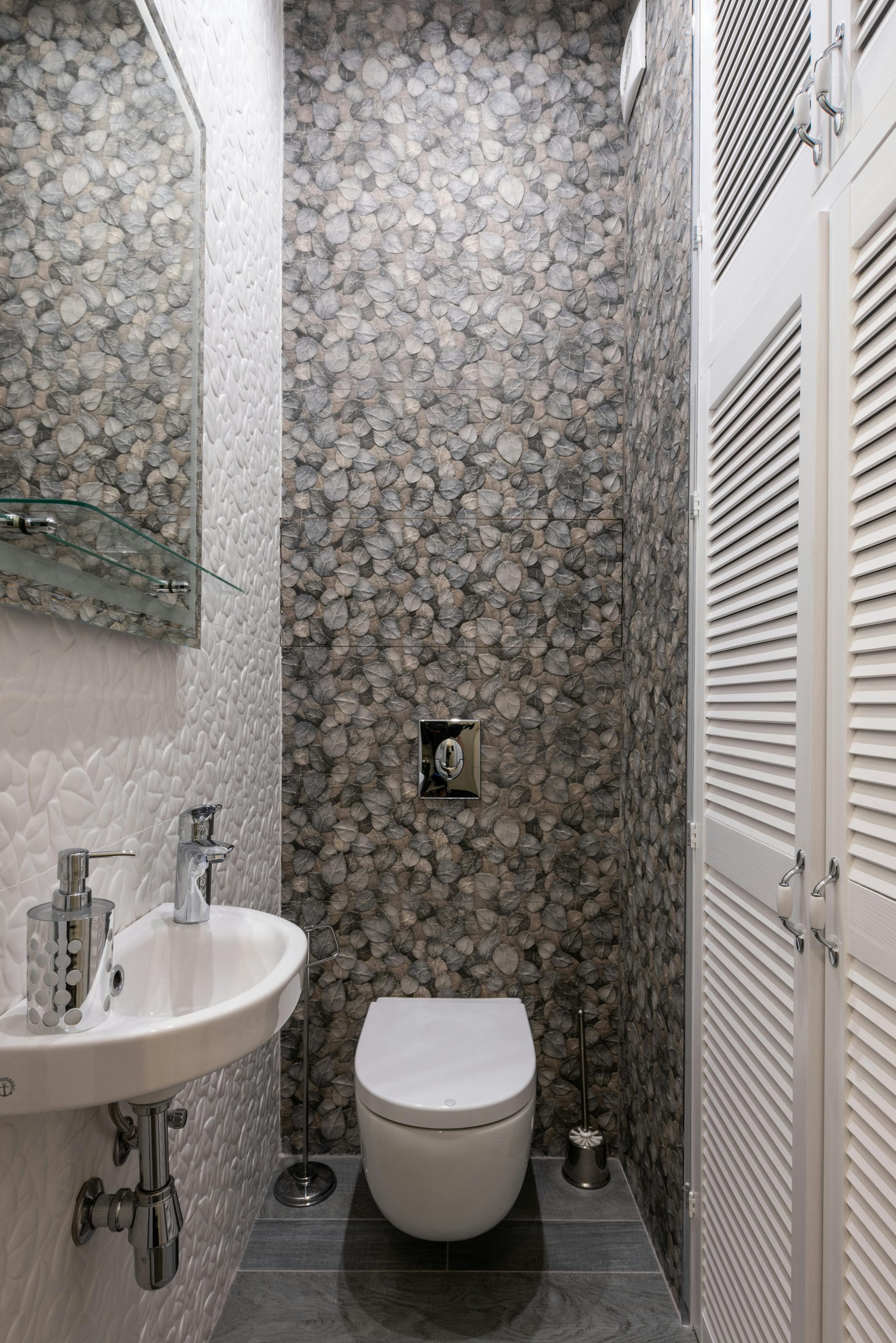 Stylish and compact bathroom featuring modern fixtures, elegant tiles, and a minimalist sink and toilet setup.