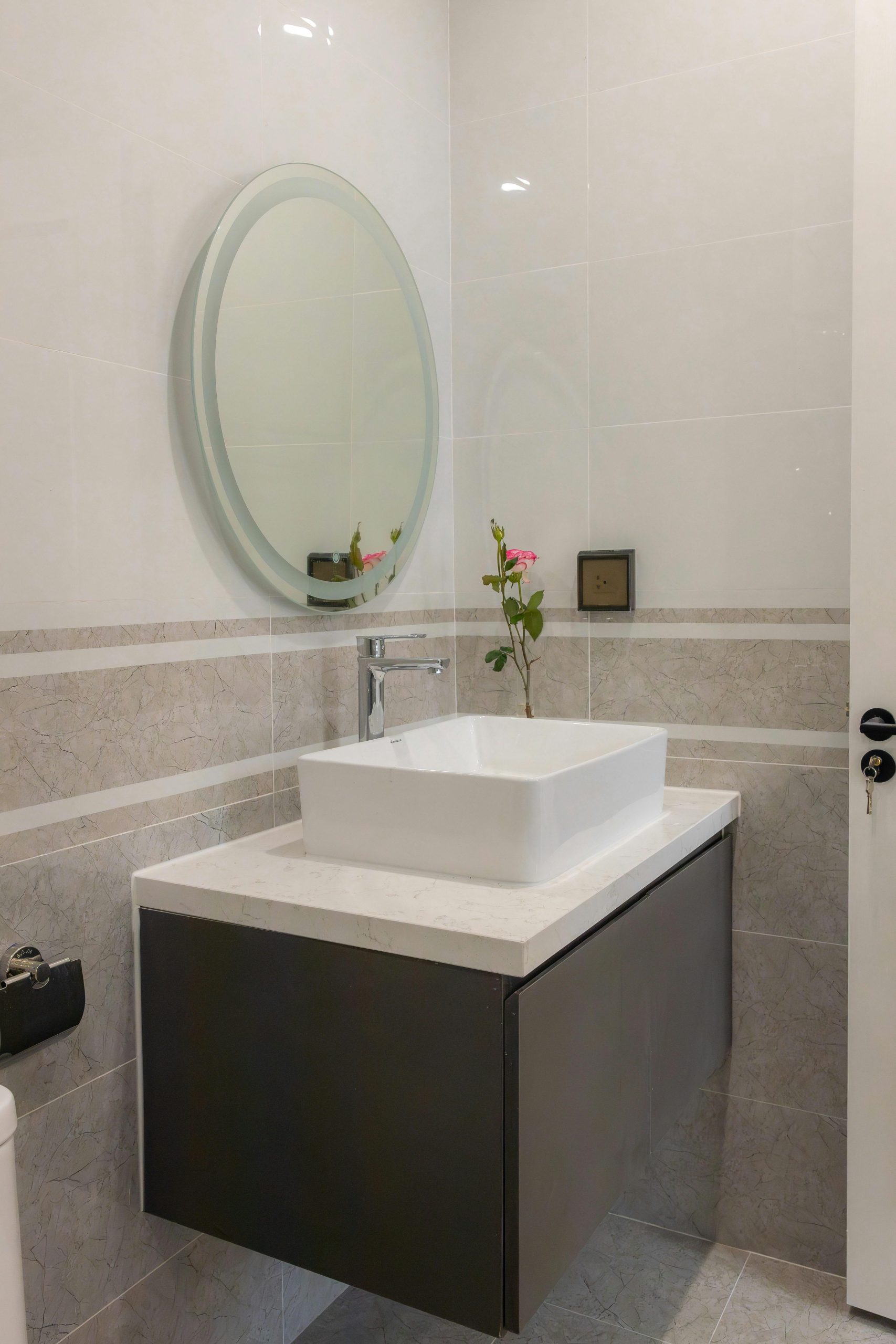 Stylish bathroom featuring a floating vanity and round mirror for a modern look.