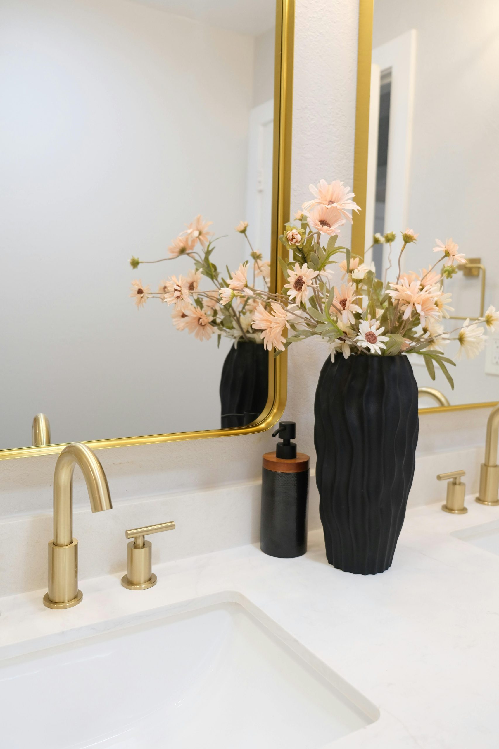 Stylish bathroom vanity with a floral arrangement and modern fixtures.