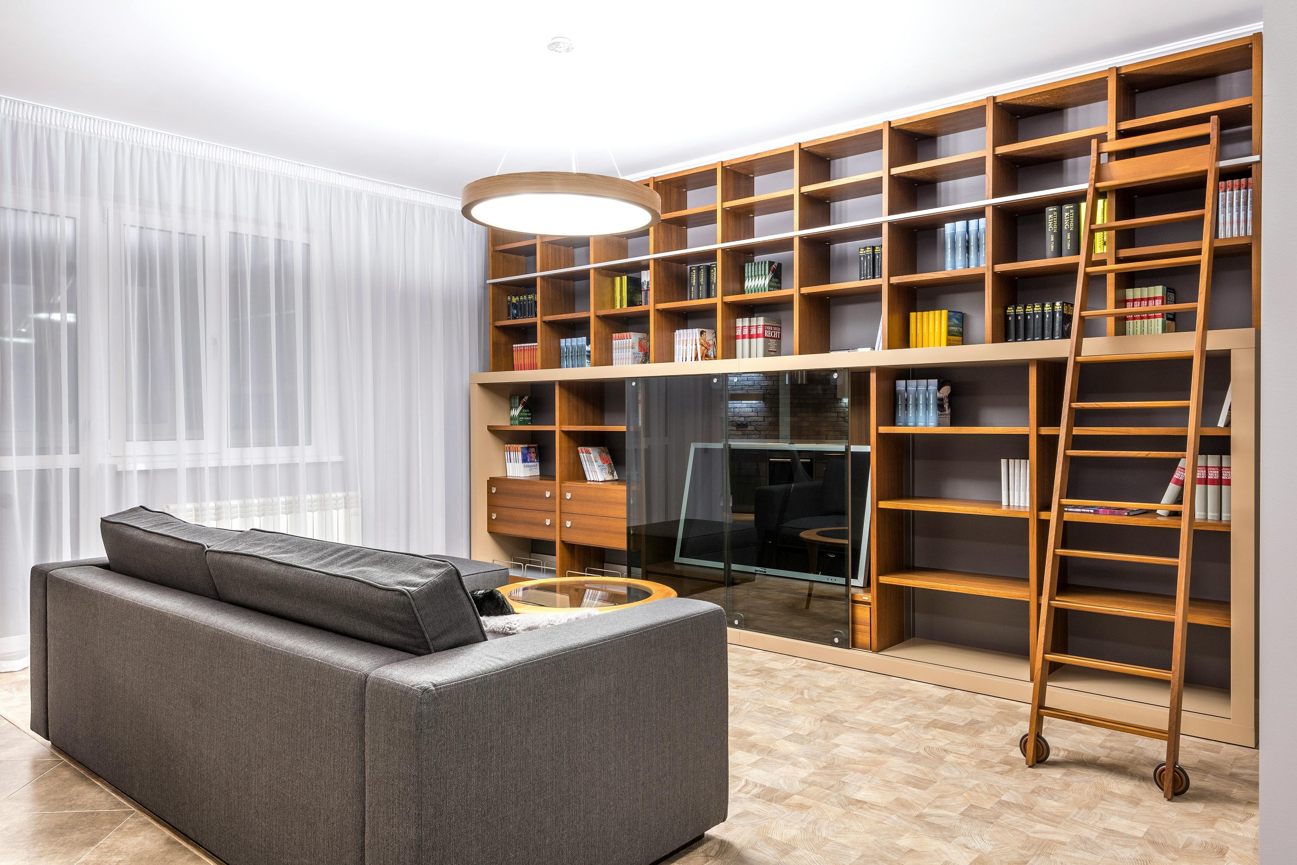Stylish living room features a large wooden bookcase and modern decor.