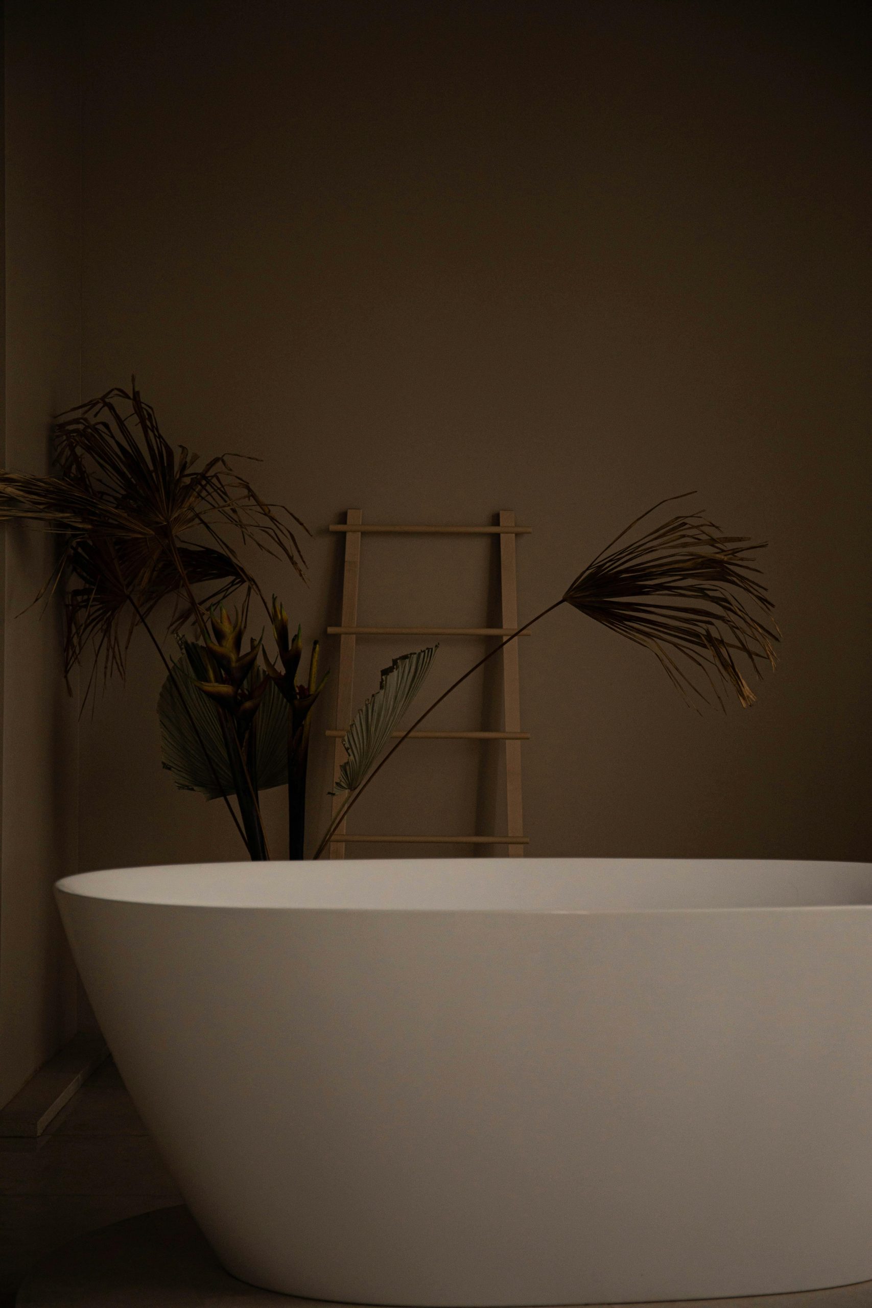Stylish minimalist bathroom featuring a white freestanding bathtub and decorative elements.