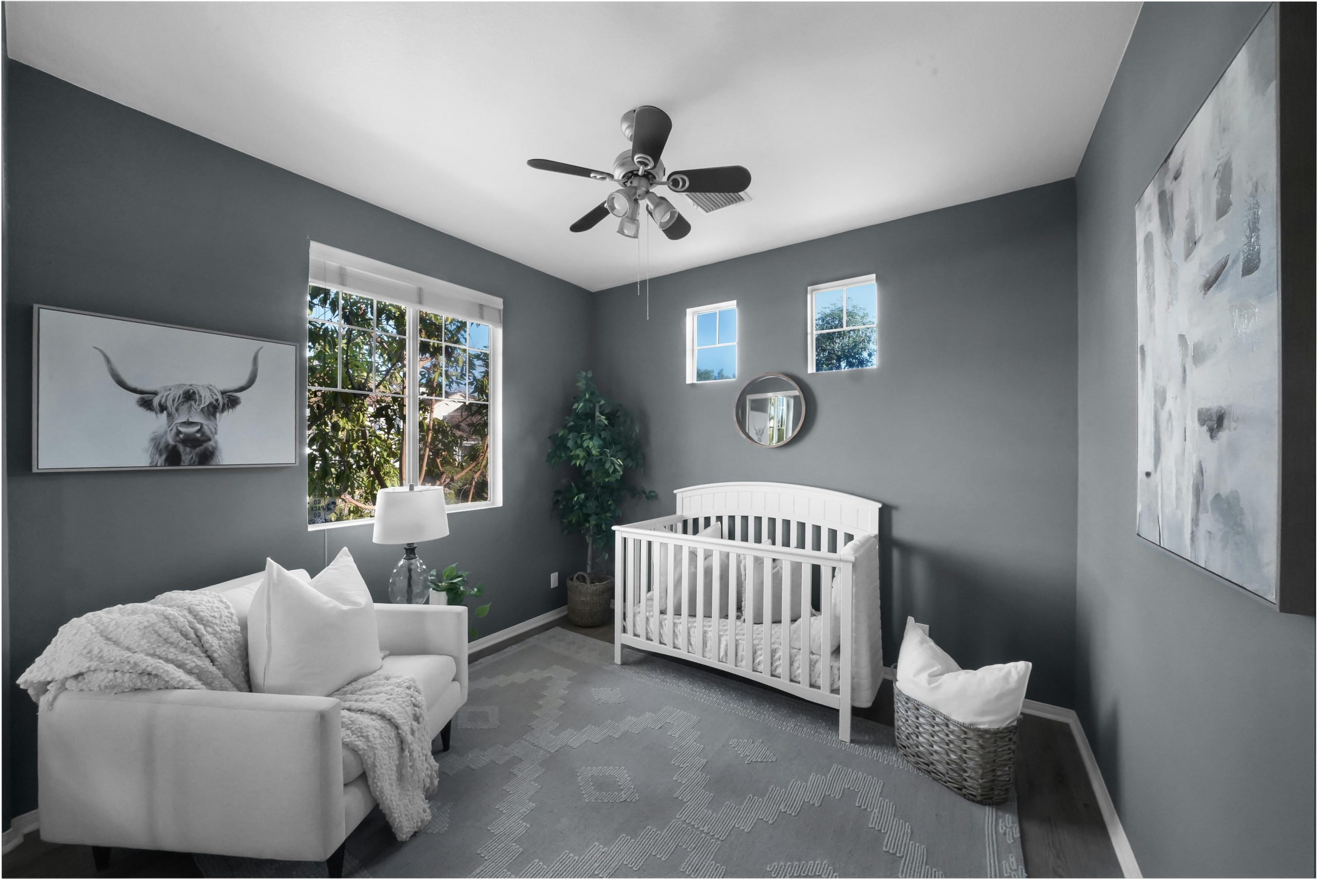 Stylish nursery featuring grey walls, a white crib, and cozy decor with natural light.
