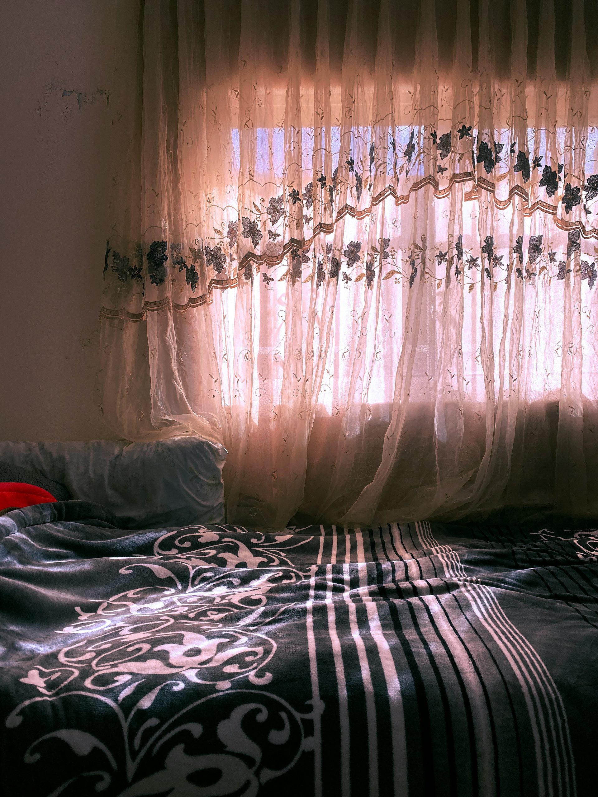 Sunlight streams through a window, illuminating the bedroom.