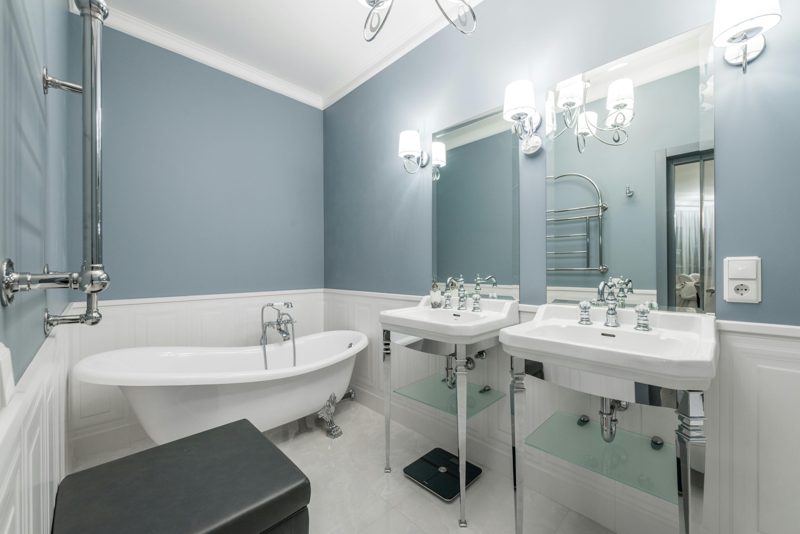 White bathtub placed near sinks under mirrors in light stylish bathroom in contemporary apartment