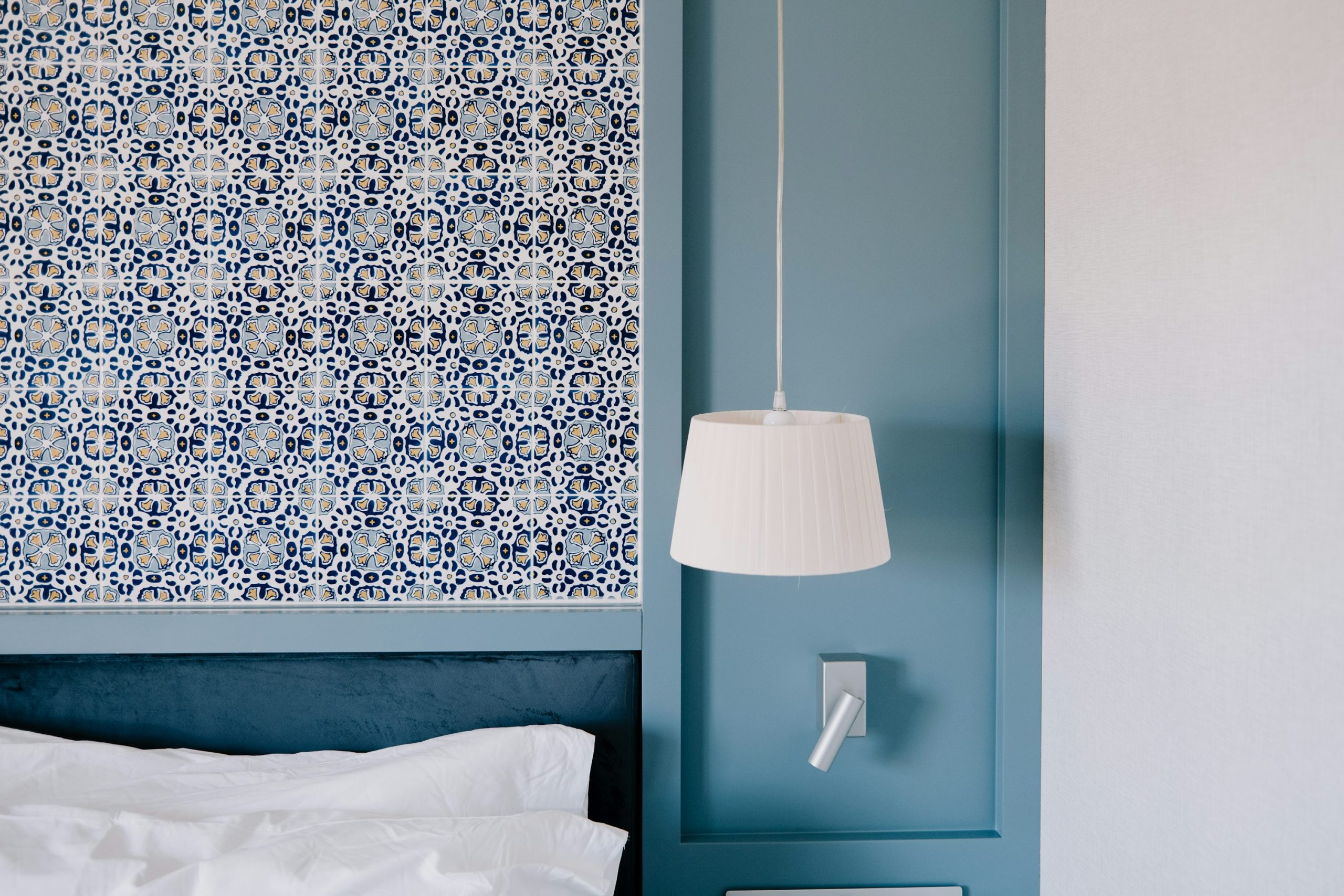 A bedroom with a blue headboard and a white bed photo – Free Bedroom Image on Unsplash