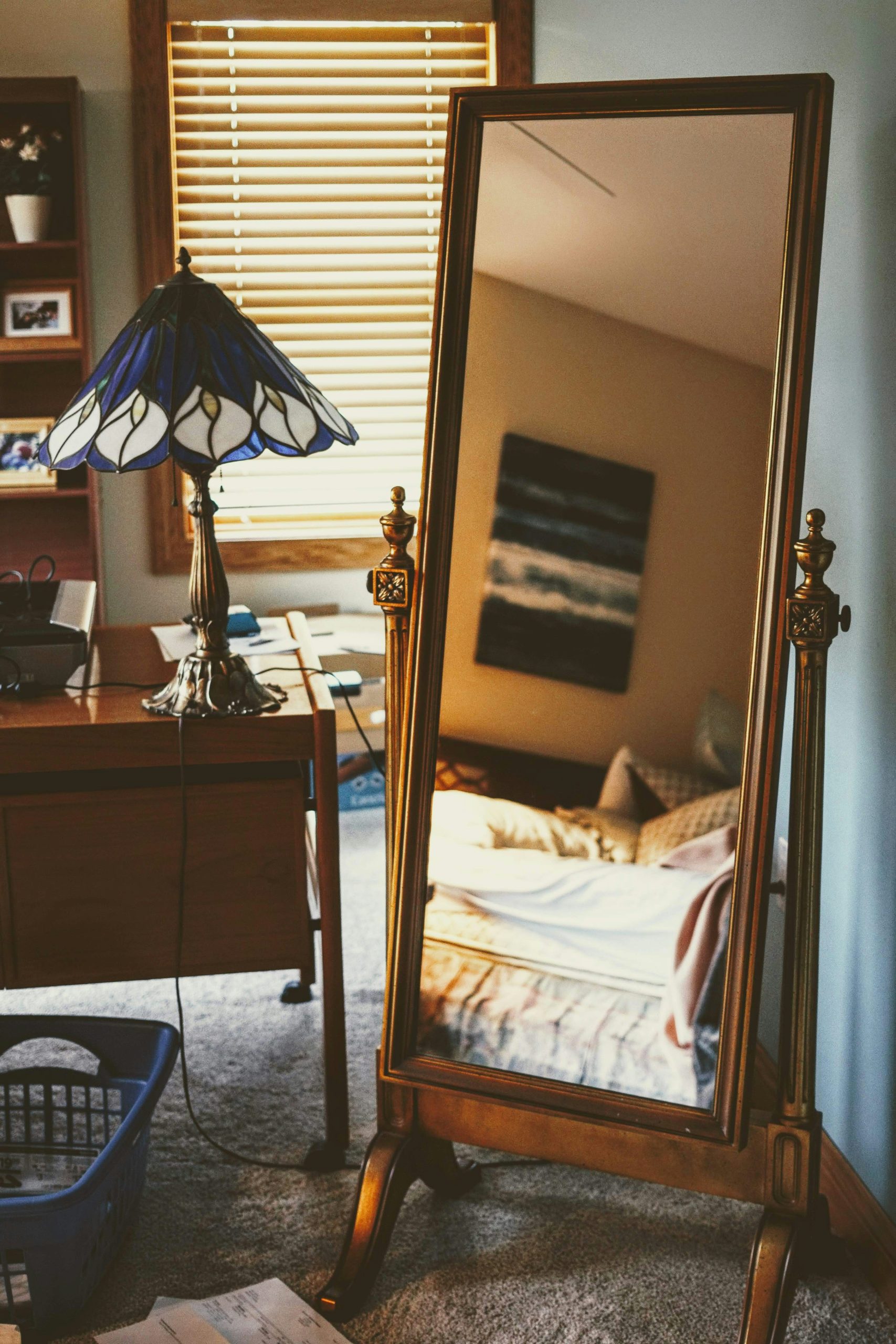 a bedroom with a mirror and a lamp