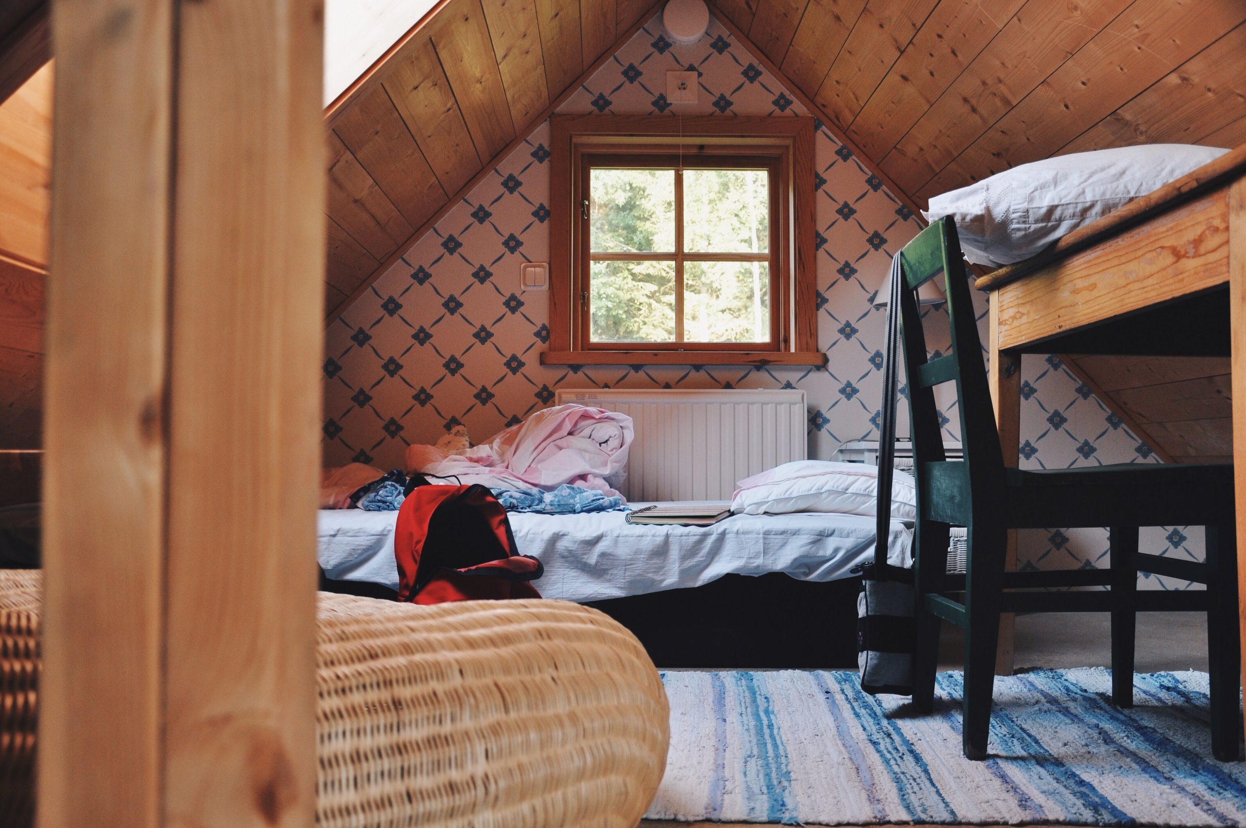 A cozy rustic attic bedroom with natural light and simple decor.