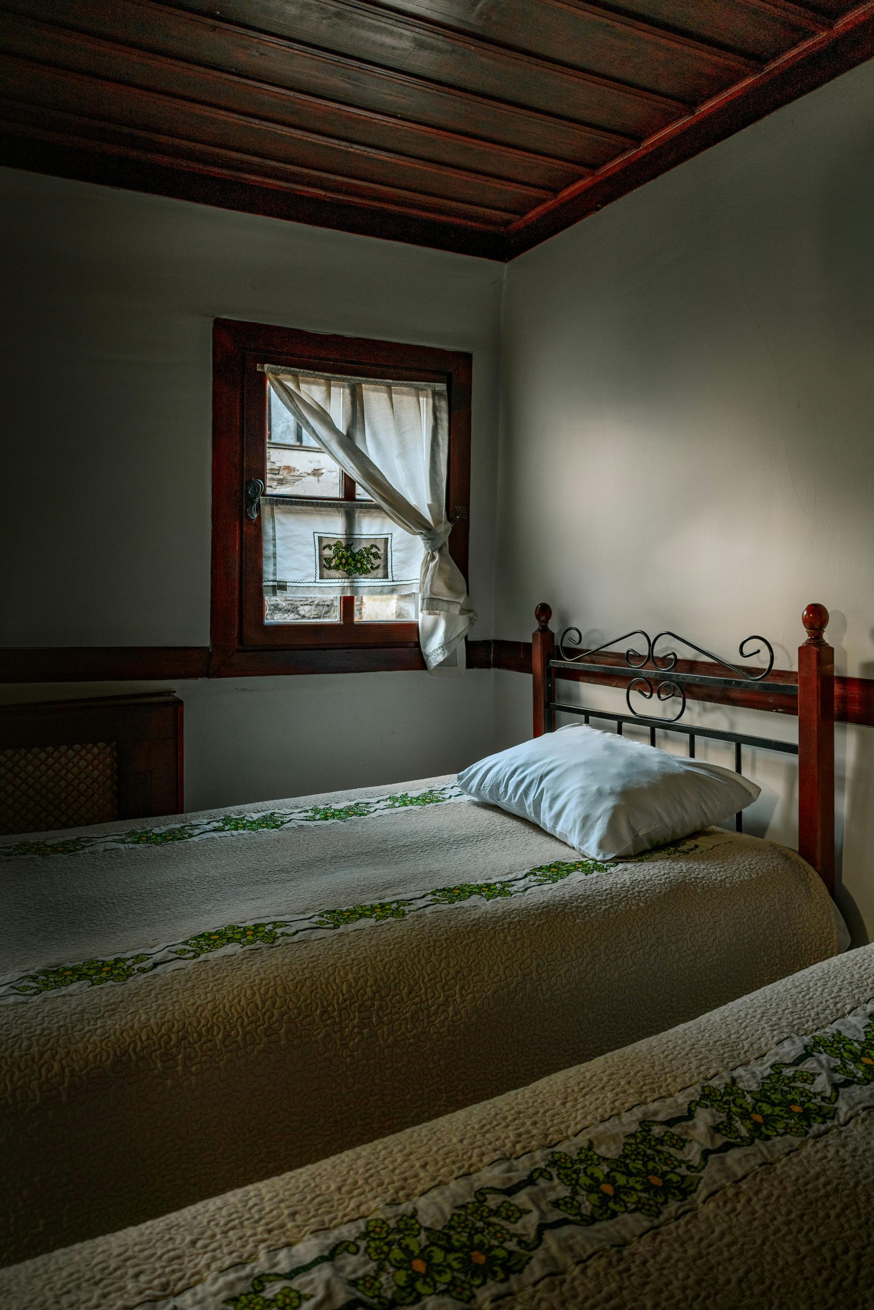 A cozy vintage bedroom featuring a single bed and natural window light, perfect for inviting rest.