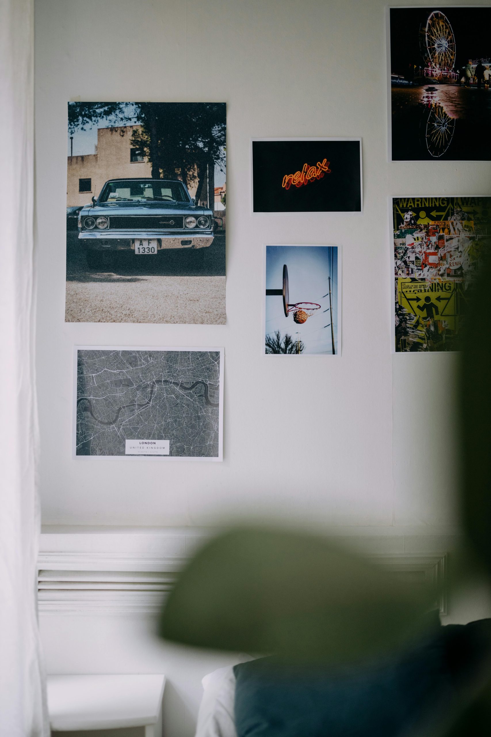 A creatively arranged display of posters and photos on an indoor wall.
