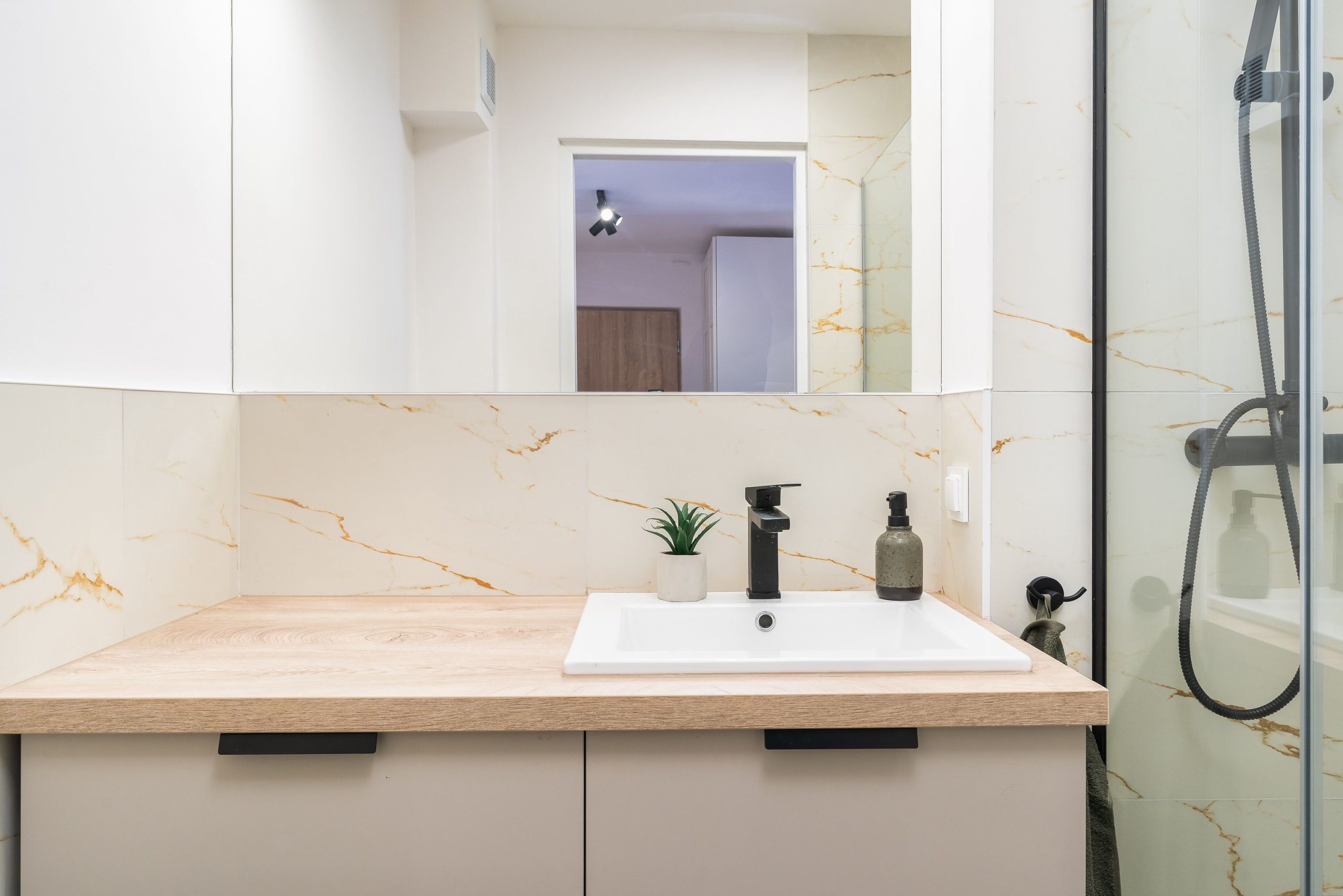 A minimalist bathroom vanity with wood countertop and elegant fixtures.