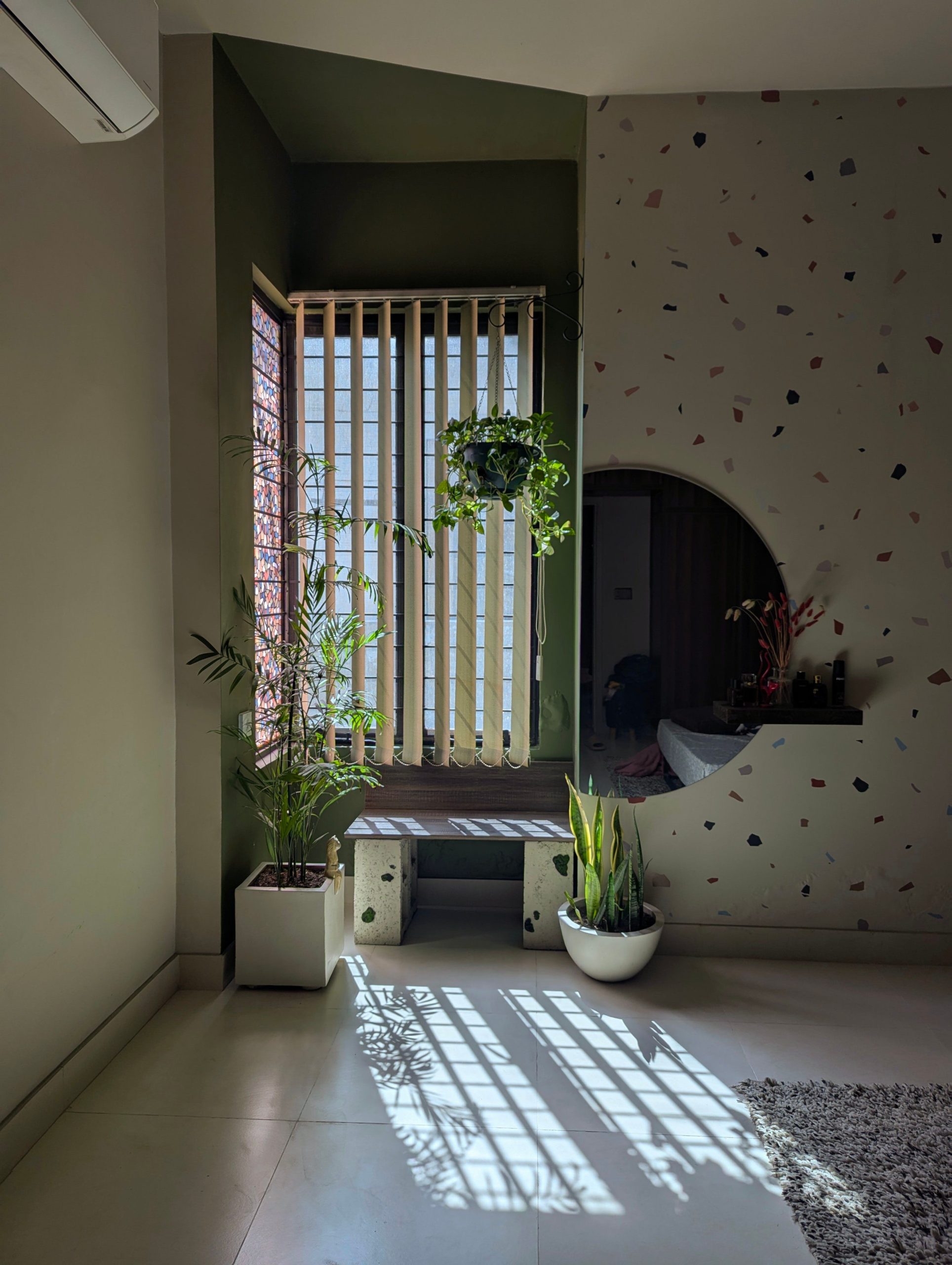 A stylish living room with natural light, modern decor, and lush indoor plants.