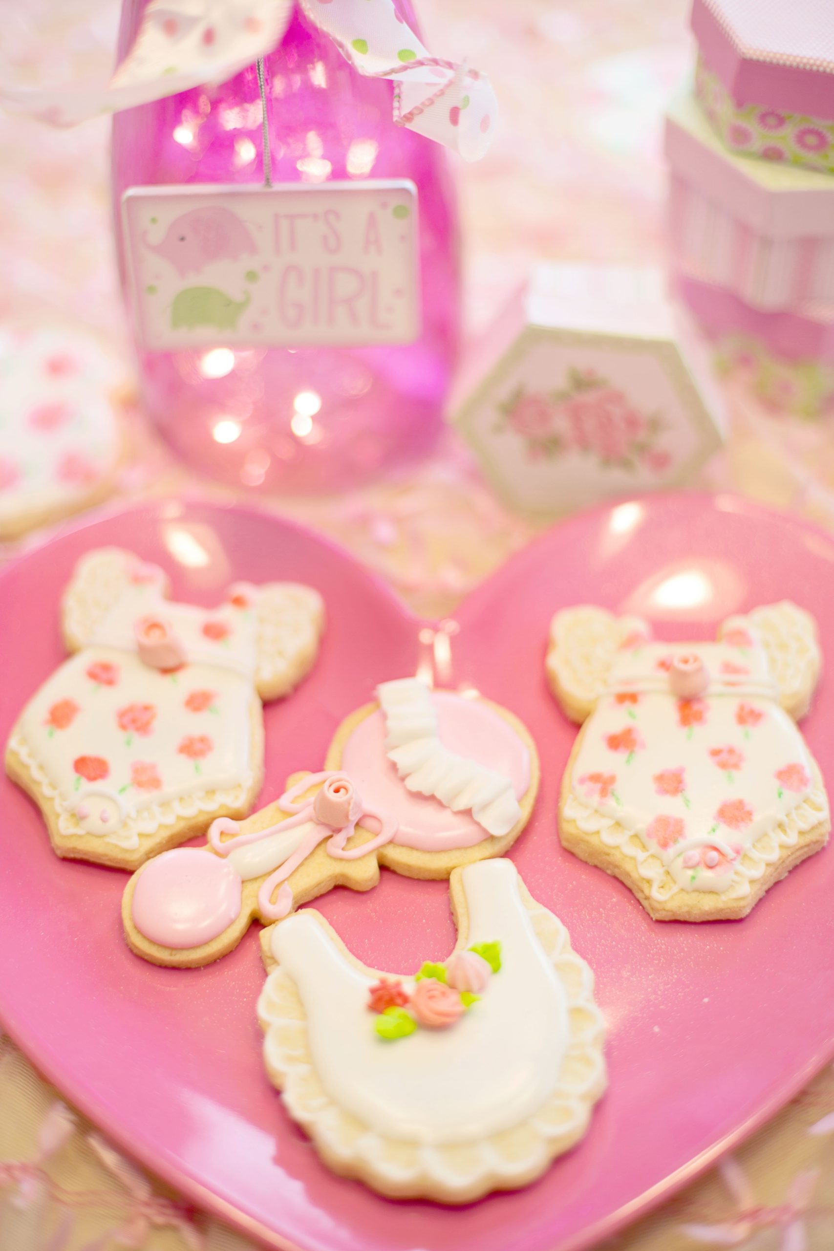Beautifully decorated cookies for a baby girl shower, featuring pink and floral designs.