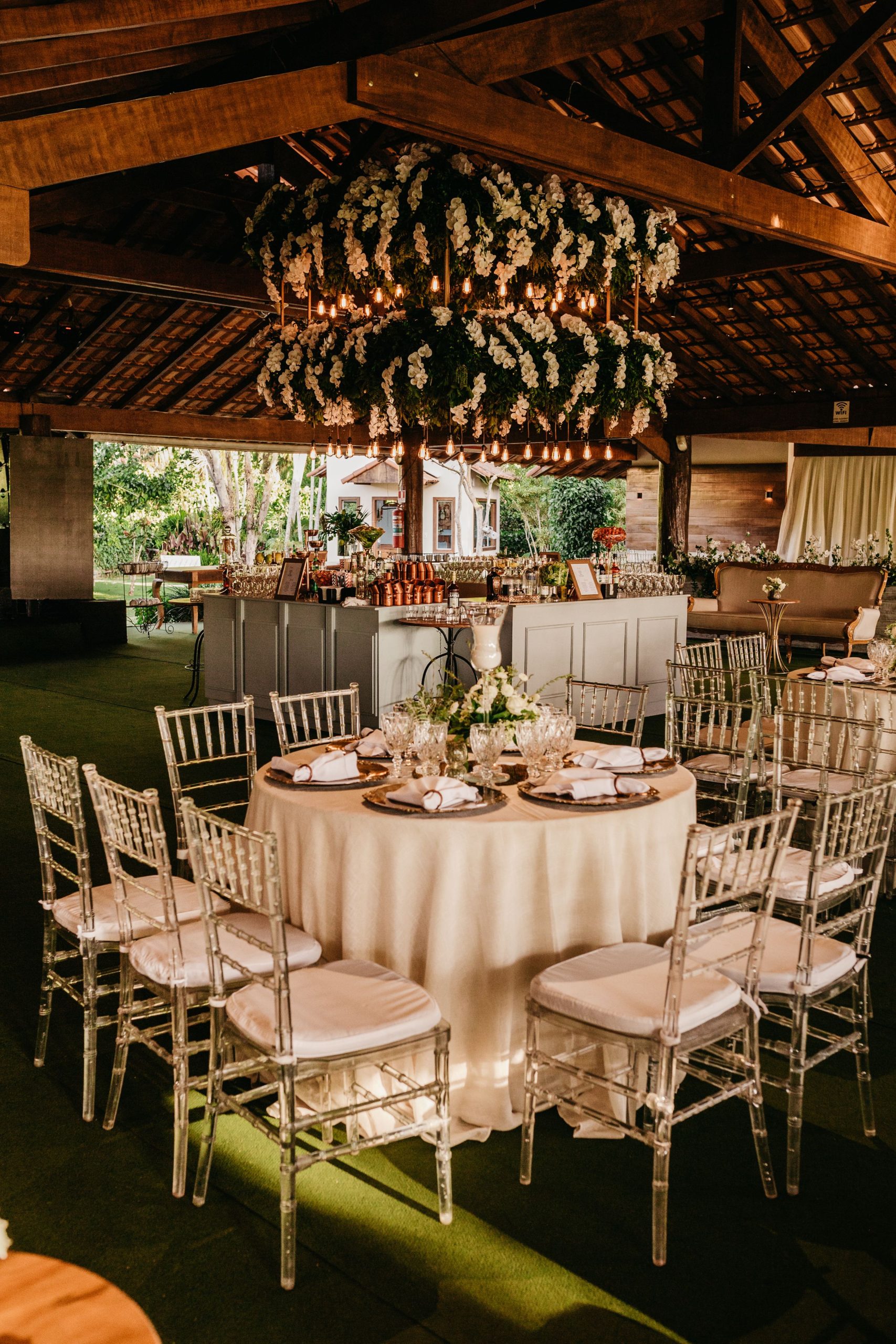 Beautifully decorated wedding reception indoors with floral chandeliers and elegant table settings.