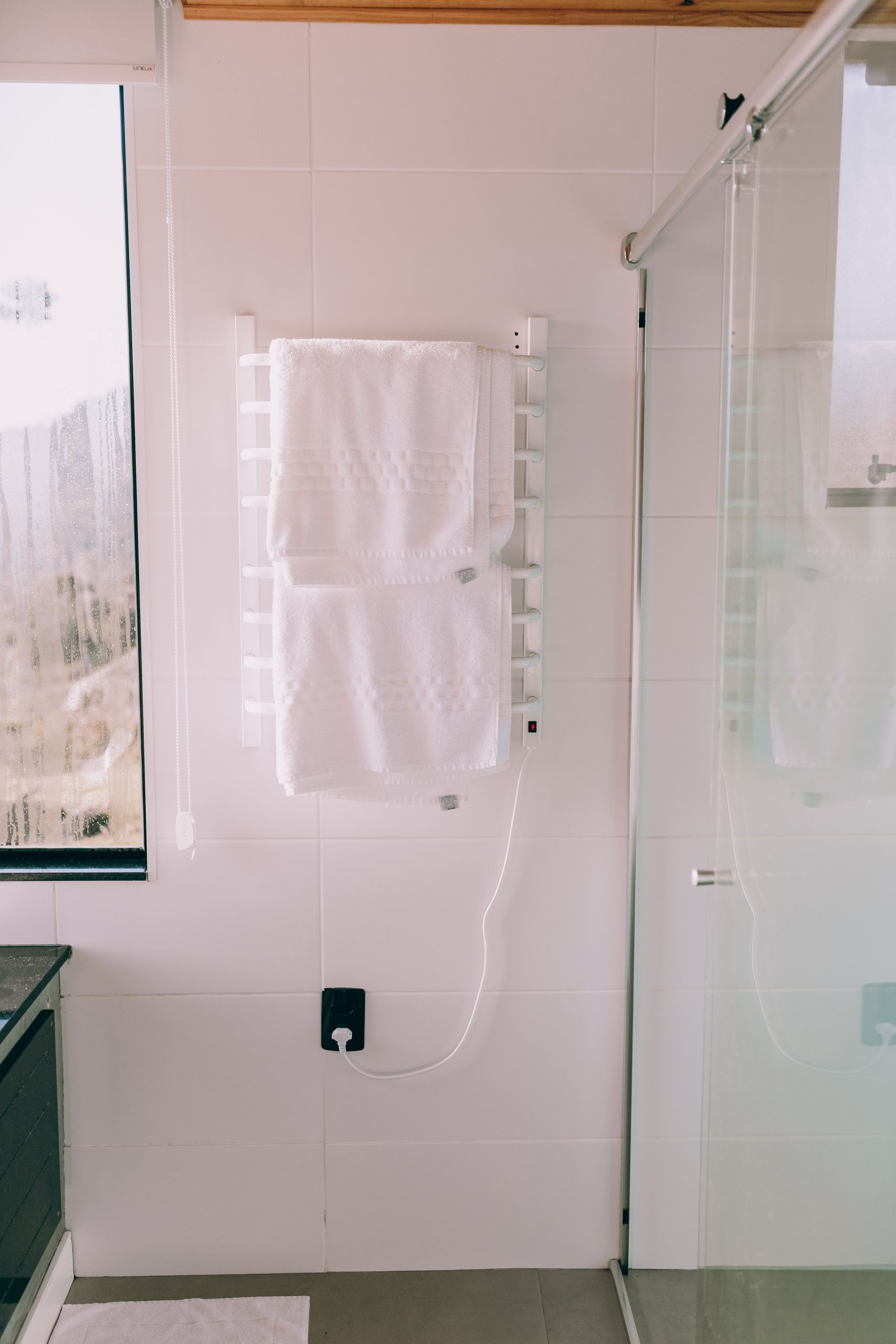 Bright and contemporary bathroom featuring a heated towel rack and glass shower.