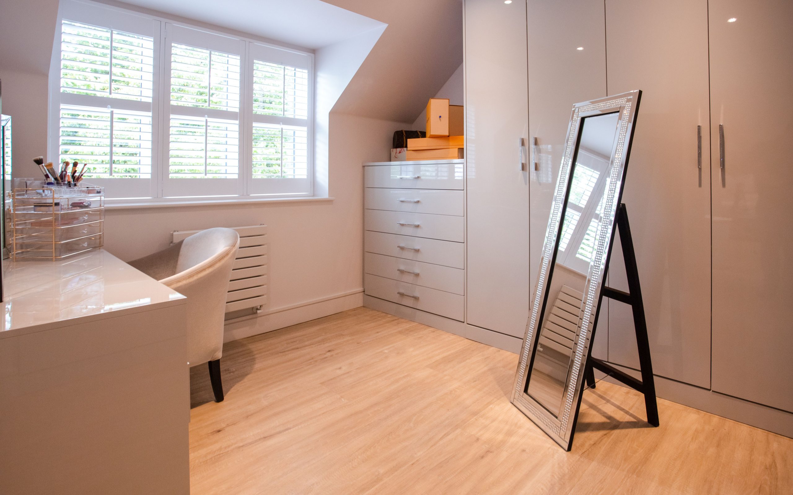 Bright and elegant minimalist bedroom with a large mirror and ample natural light, promoting serenity and modern style.