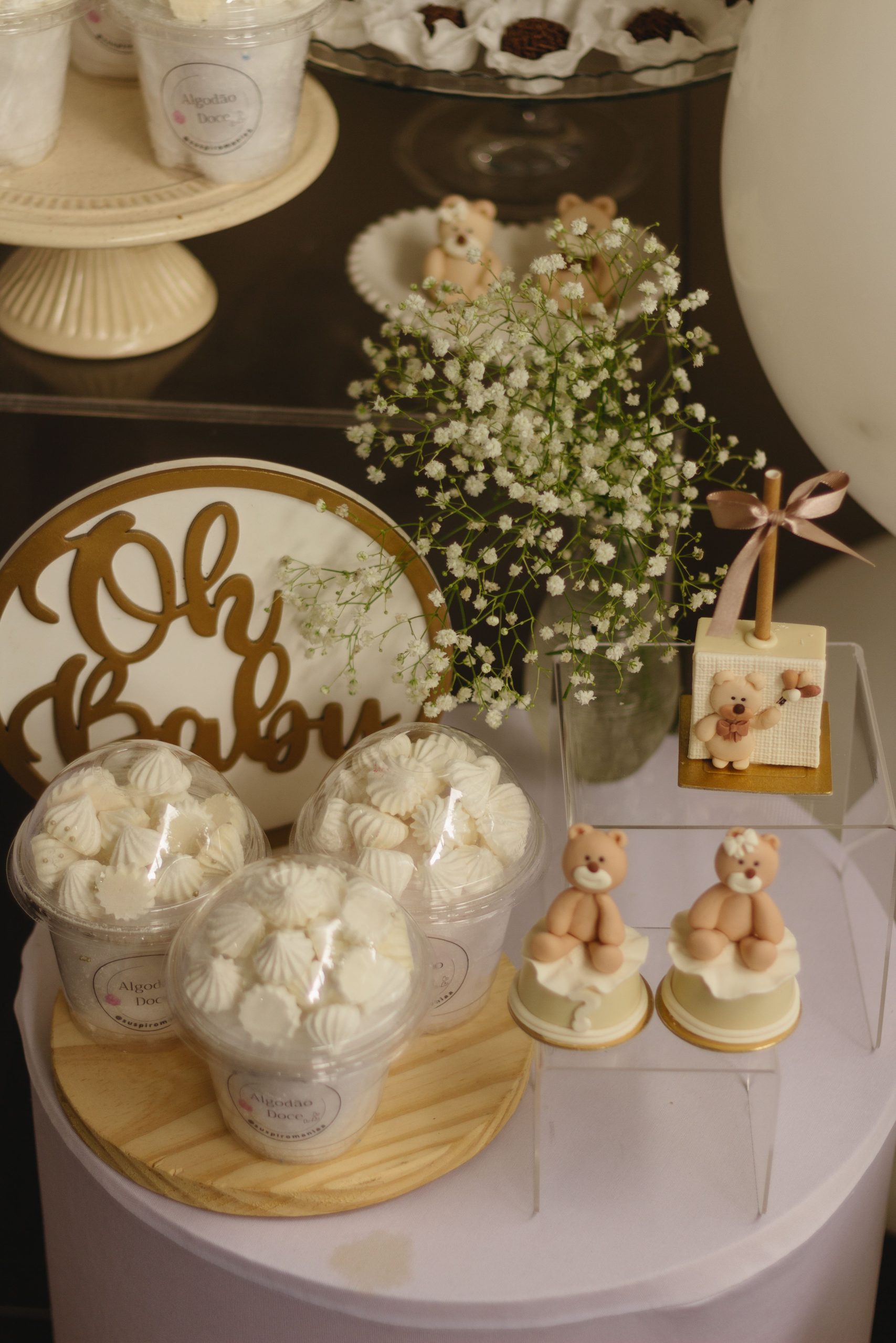 Charming baby shower setup featuring teddy bears, sweets, and floral decor.