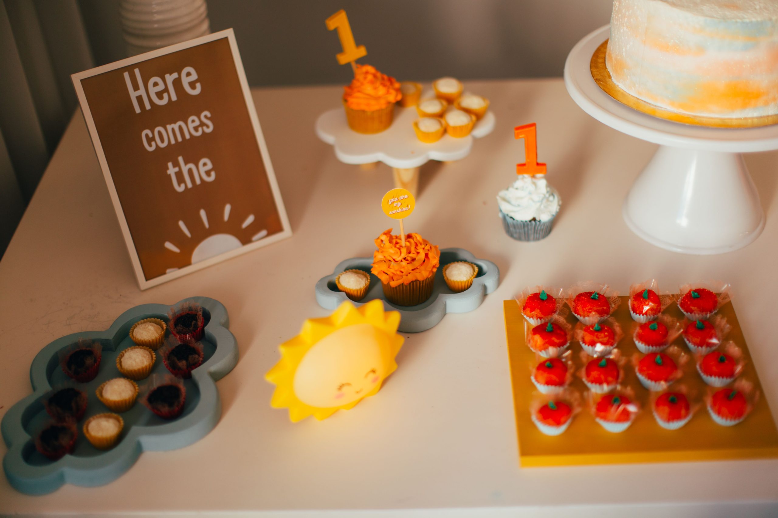 Charming first birthday party setup with cupcakes and sunny decorations.