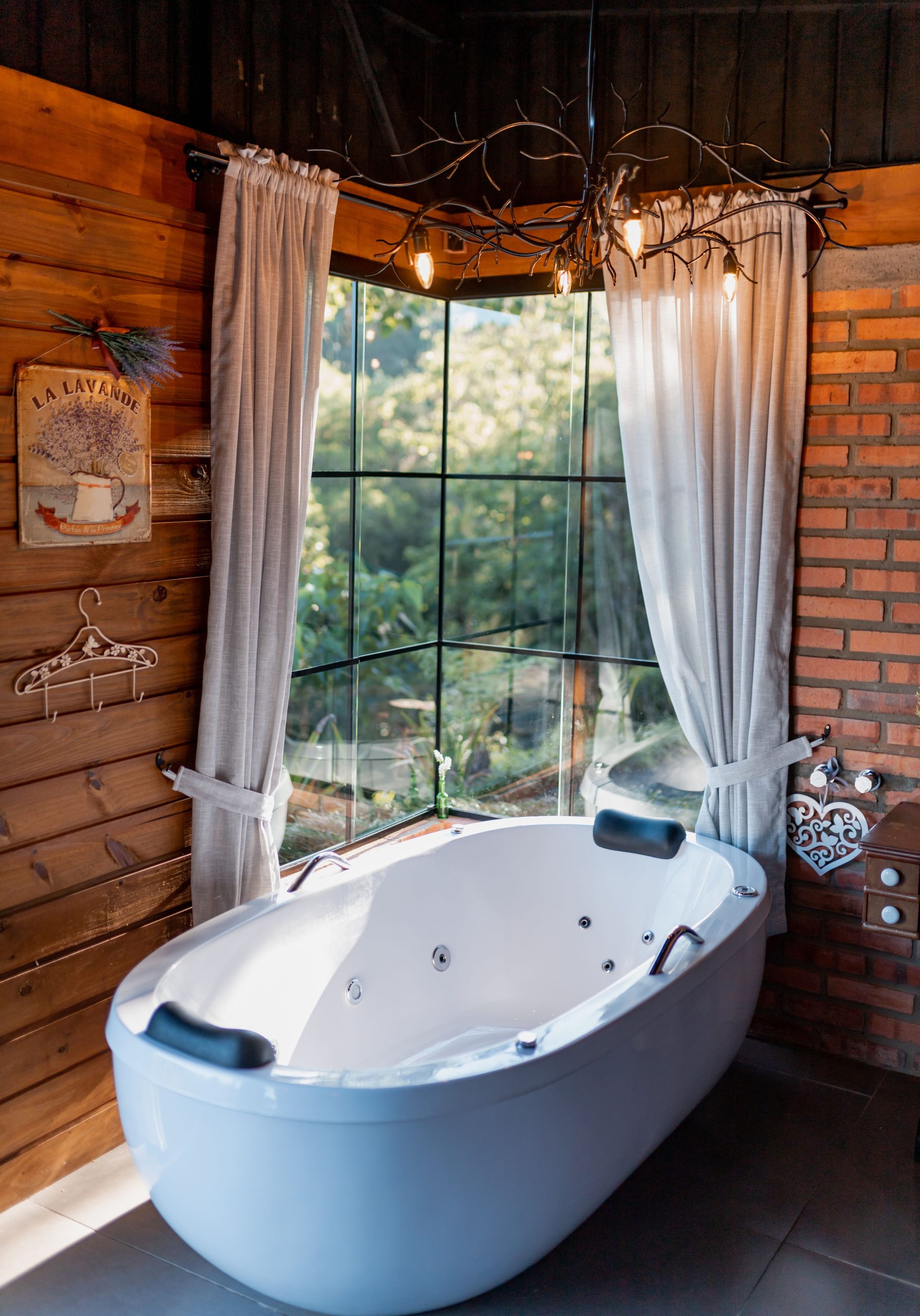 Charming rustic bathroom interior featuring a freestanding bathtub by a large window.