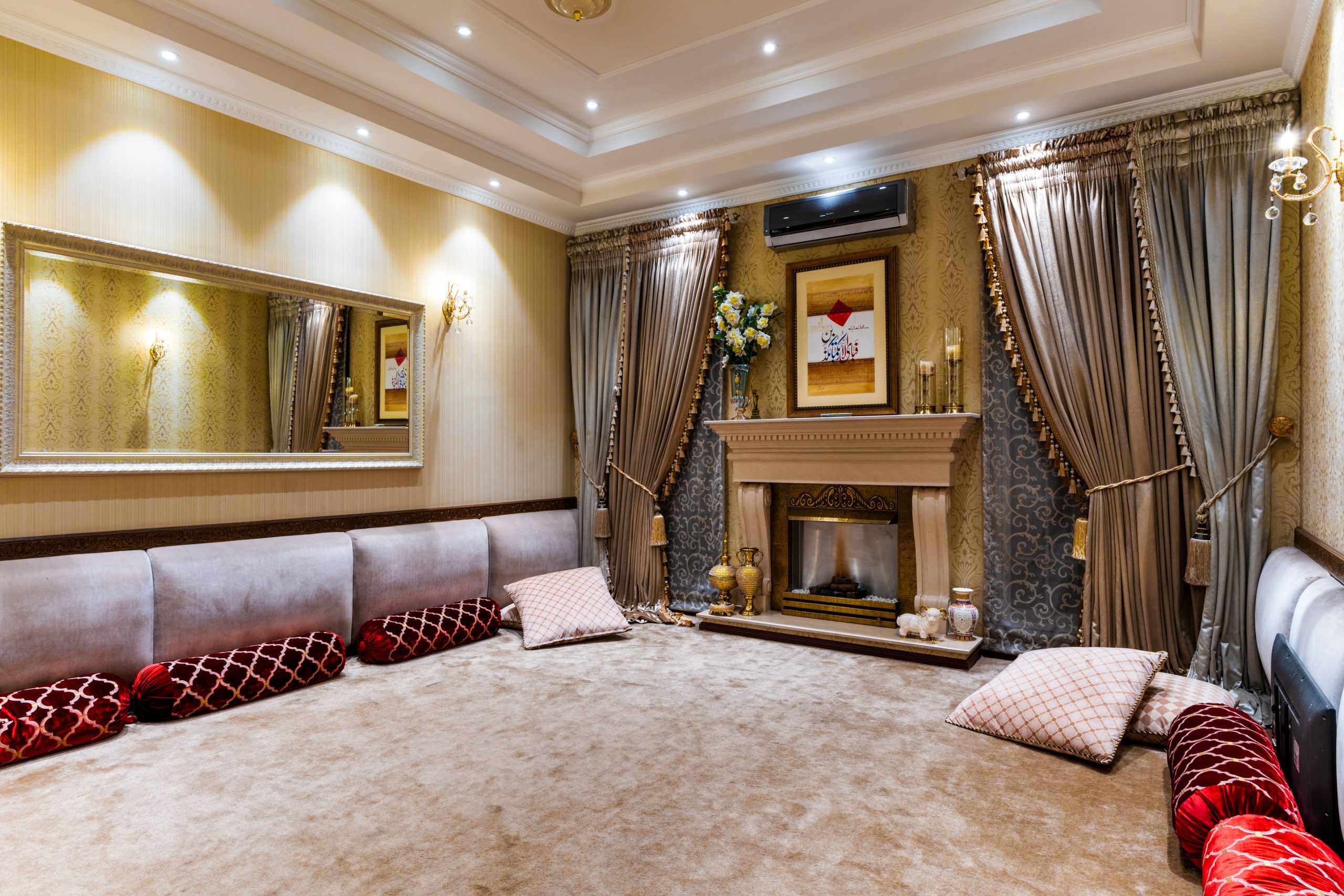 Elegant living room with a fireplace, ornate curtains, and decorative pillows showcasing luxurious interior design.