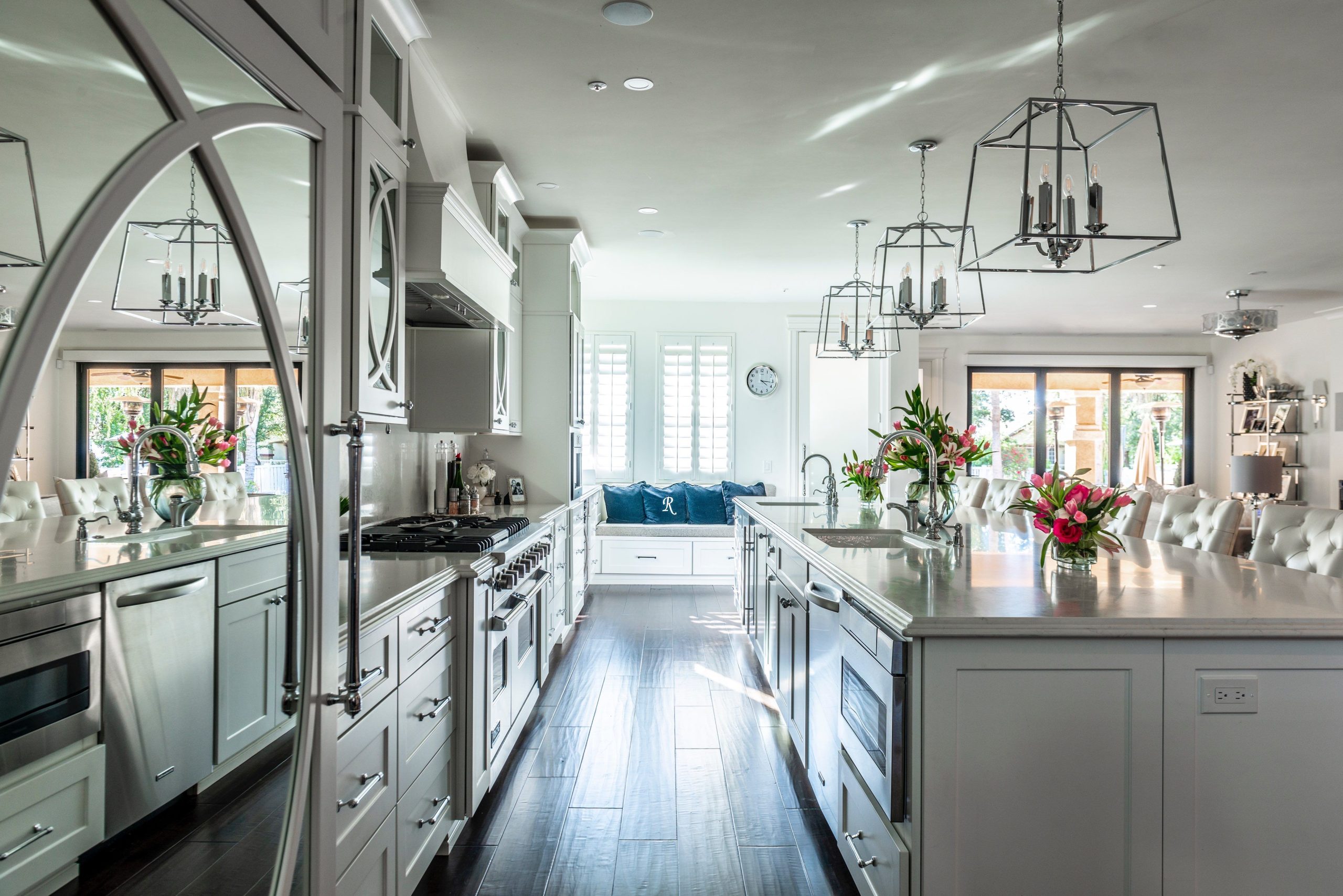 Elegant modern kitchen featuring an island, white cabinetry, and stainless steel appliances.