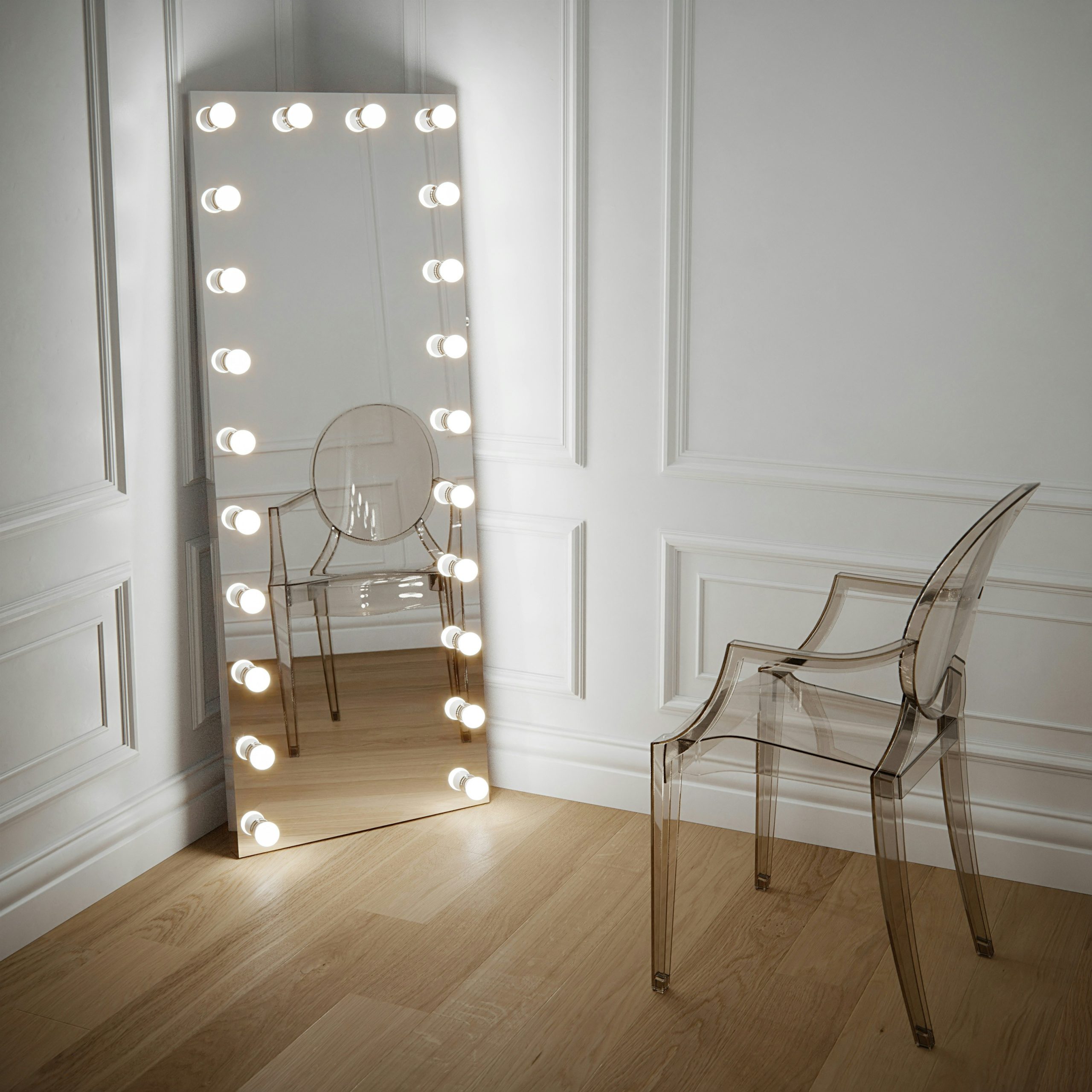 Full length mirror Hollywood style with led bulbs. Leaner mirror against a white panelled wall and crystal Kartell Louis ghost chair by Philippe Starck