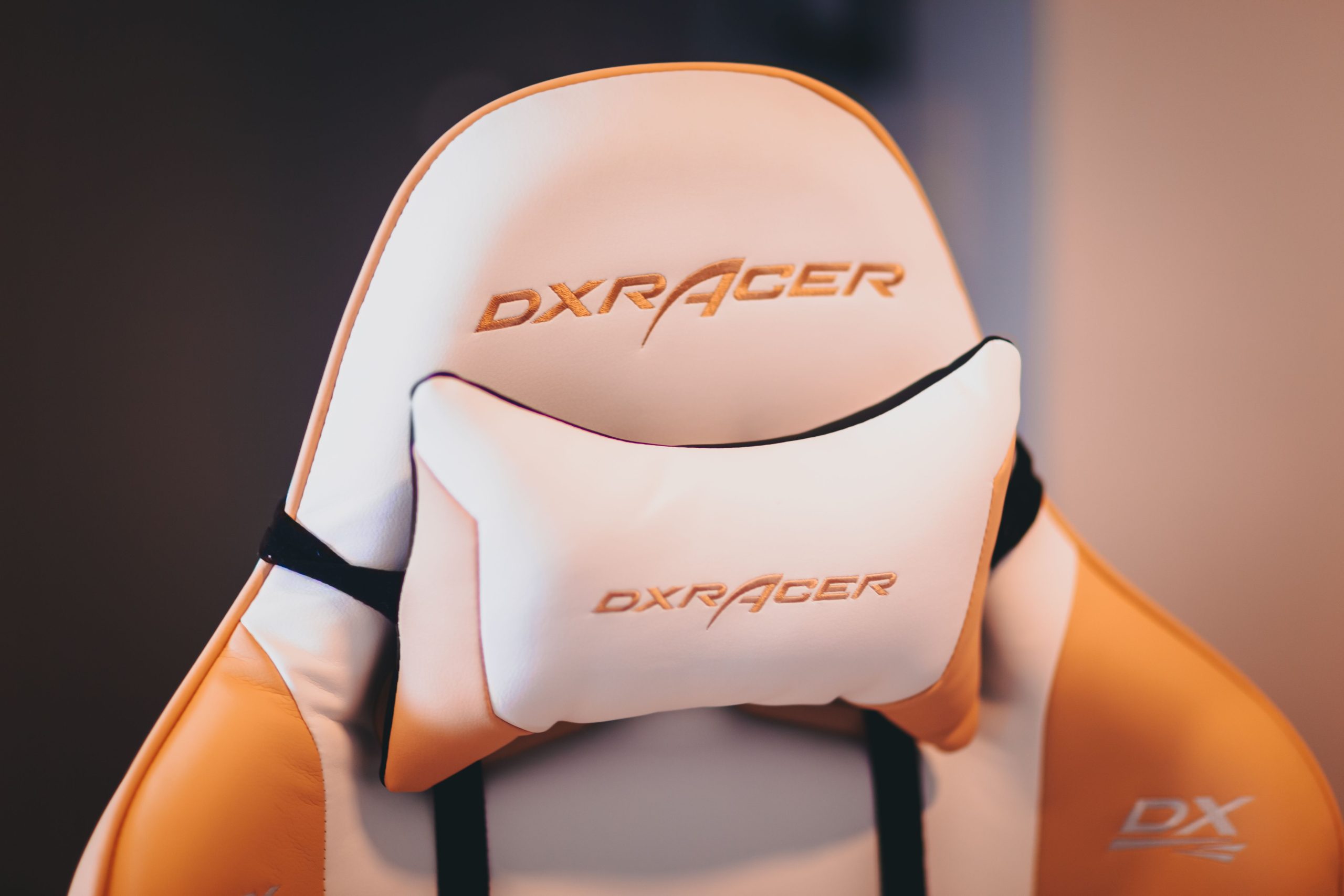 High-quality ergonomic gaming chair with cushion featuring DXRacer branding, ideal for comfort and support.