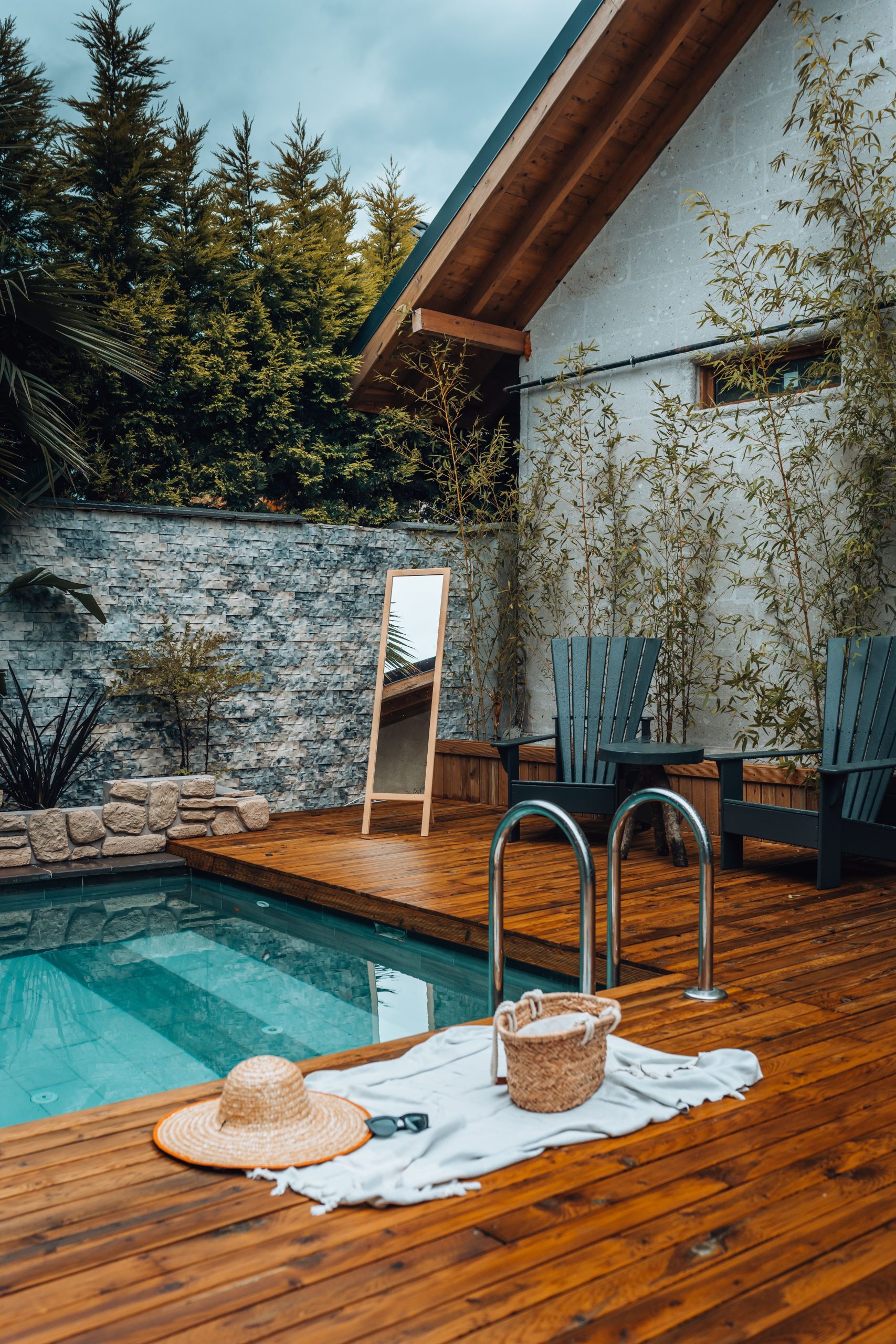 Inviting wooden patio with a pool, deck chairs, and summer essentials, perfect for relaxation.
