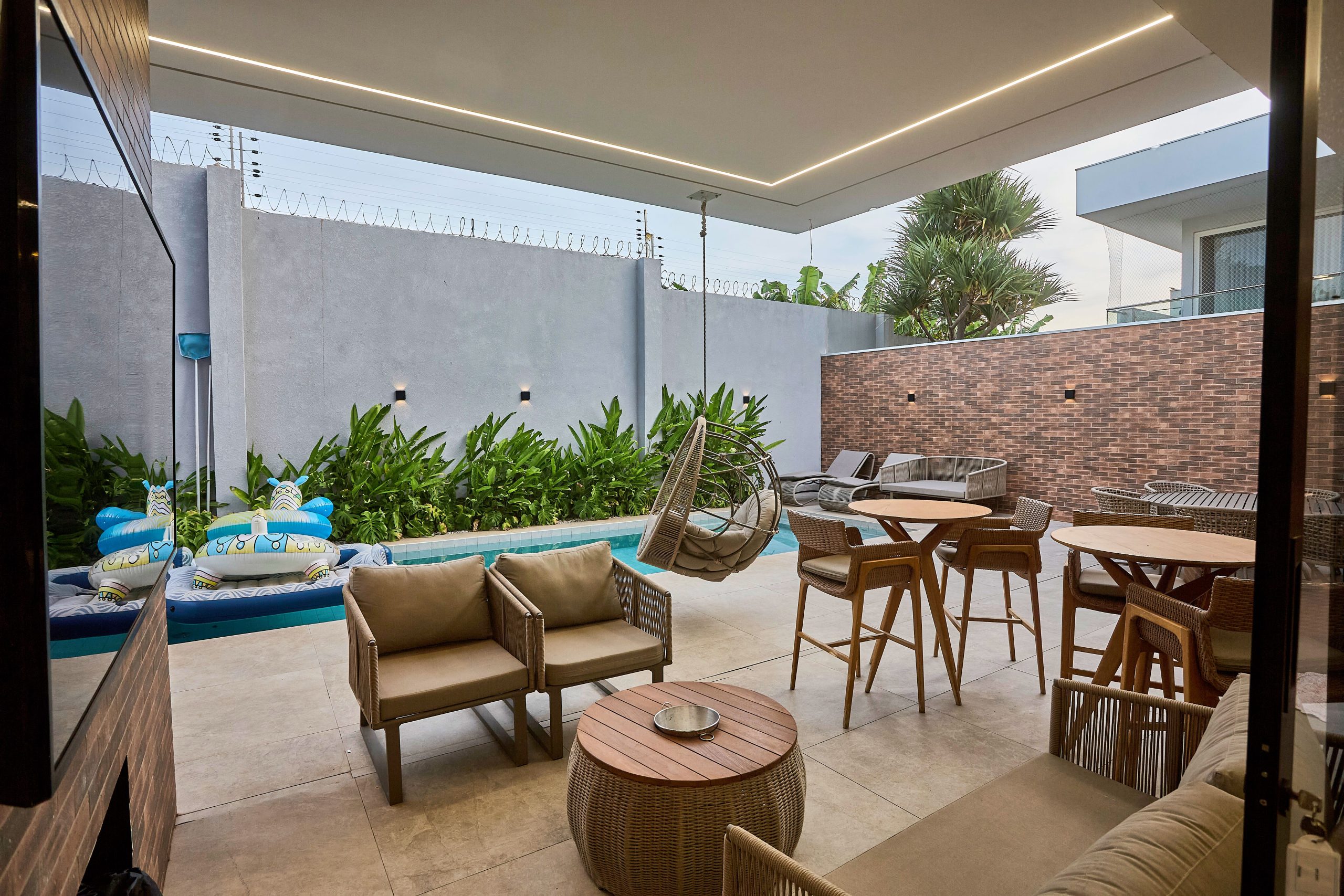 Luxurious outdoor patio setup with stylish seating and pool view.