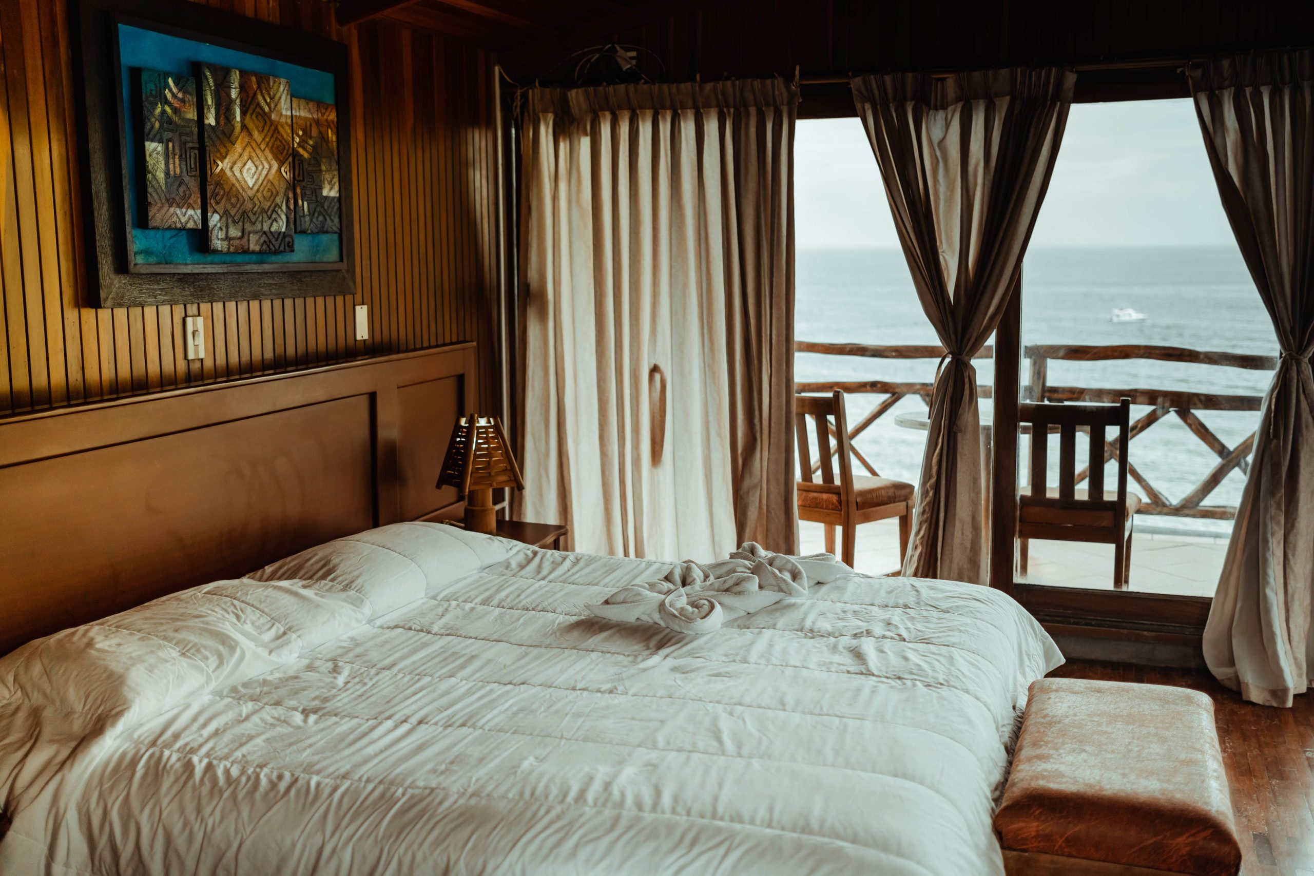 Luxurious seaside bedroom featuring a plush bed, elegant decor, and stunning ocean view for a serene escape.