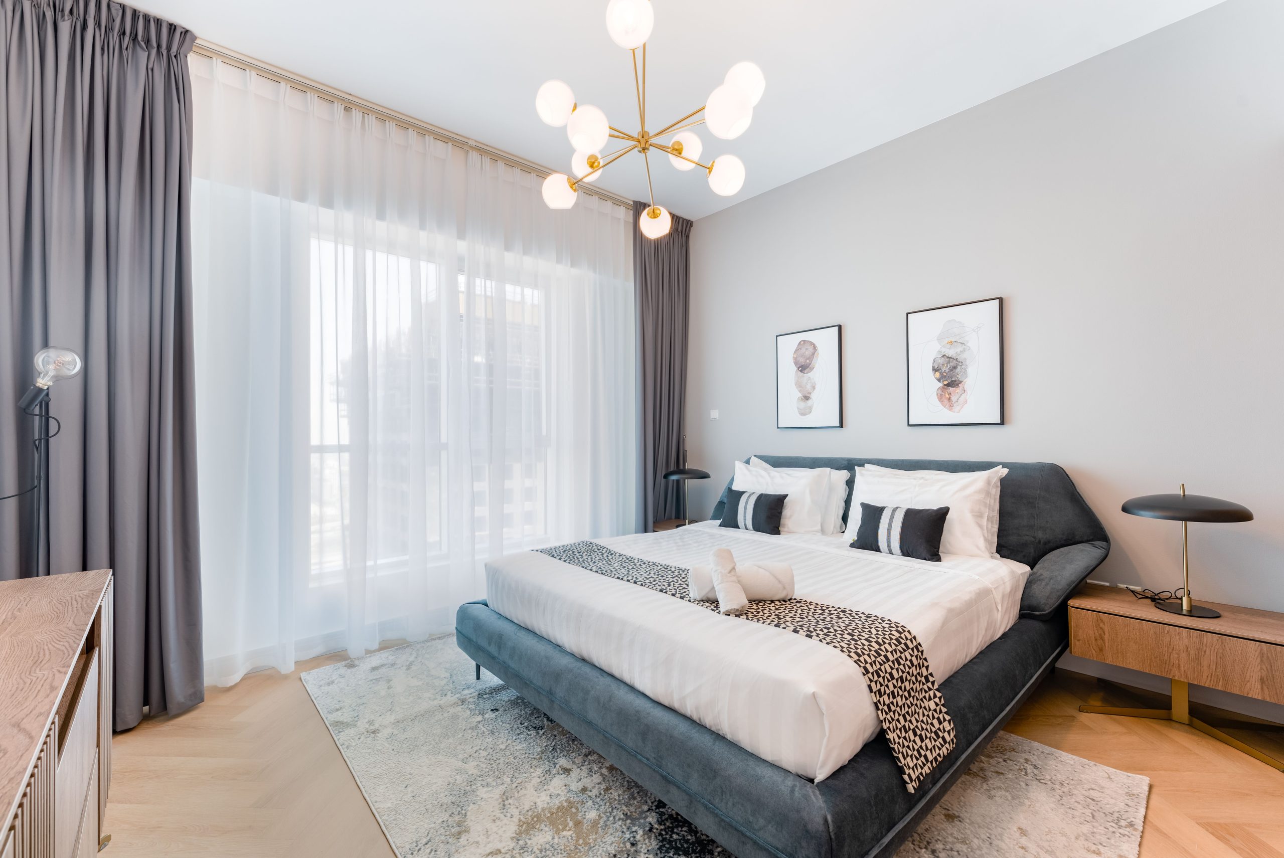 Modern bedroom interior with luxurious design featuring a king-sized bed, chic lighting, and elegant decor.