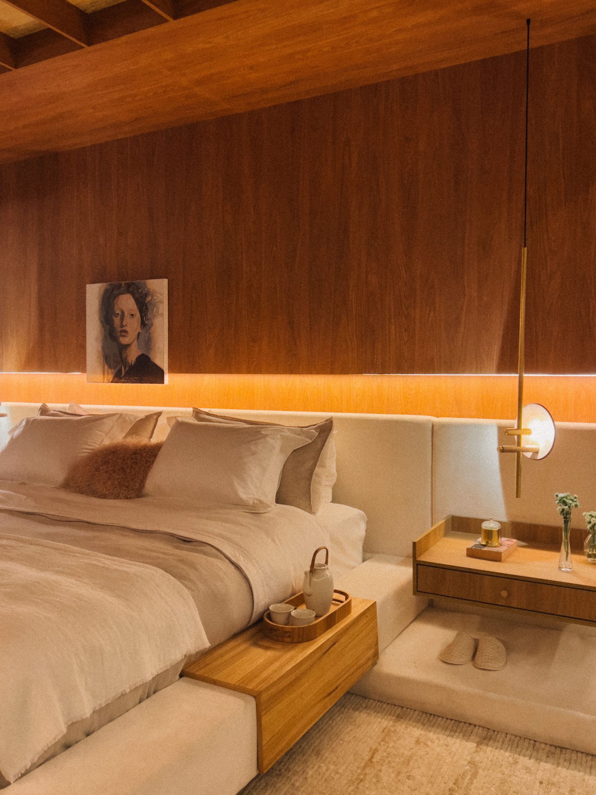 Modern bedroom interior with warm tones and minimalistic design elements.